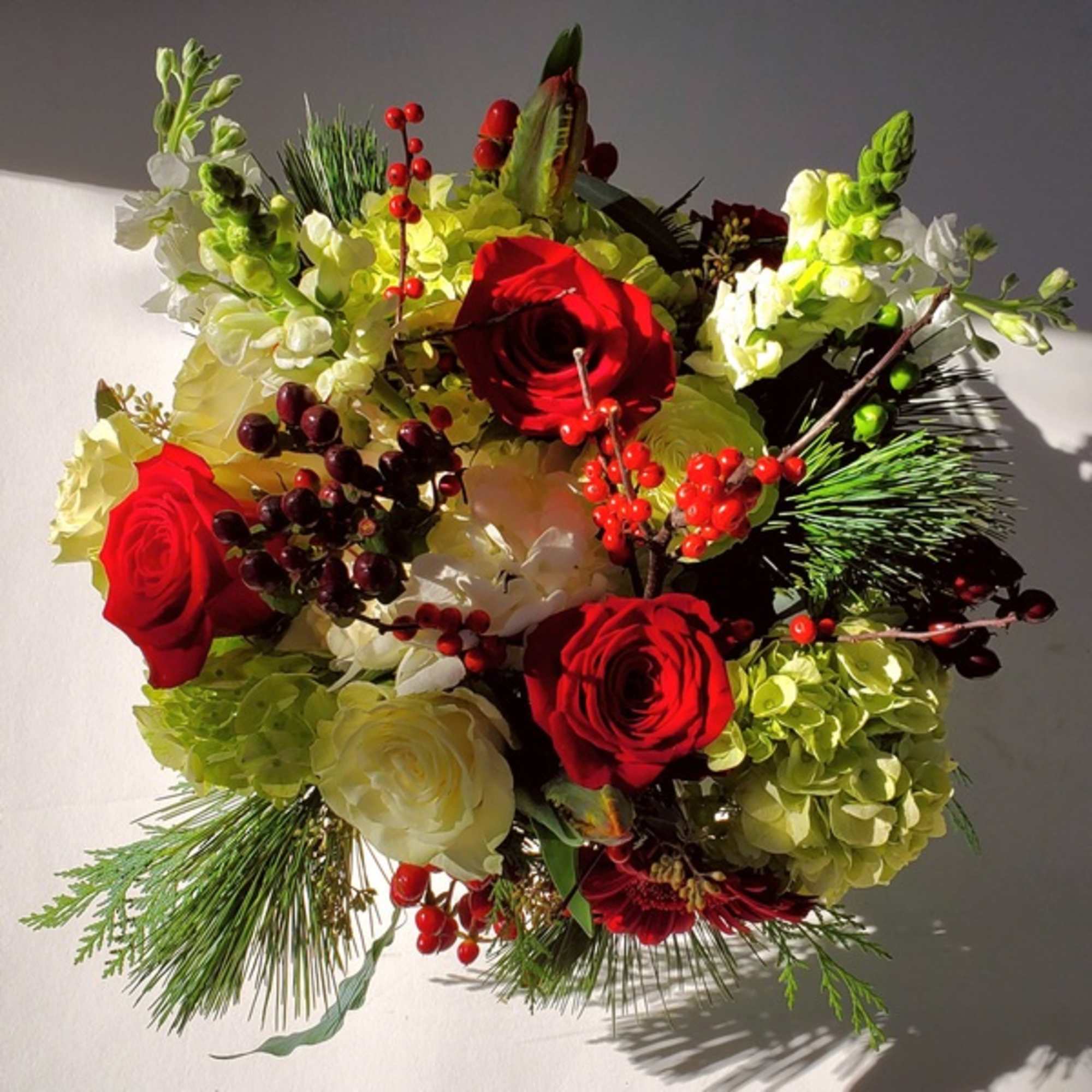 Vase arrangement of premium red, white (and sometimes pink) flowers and berries