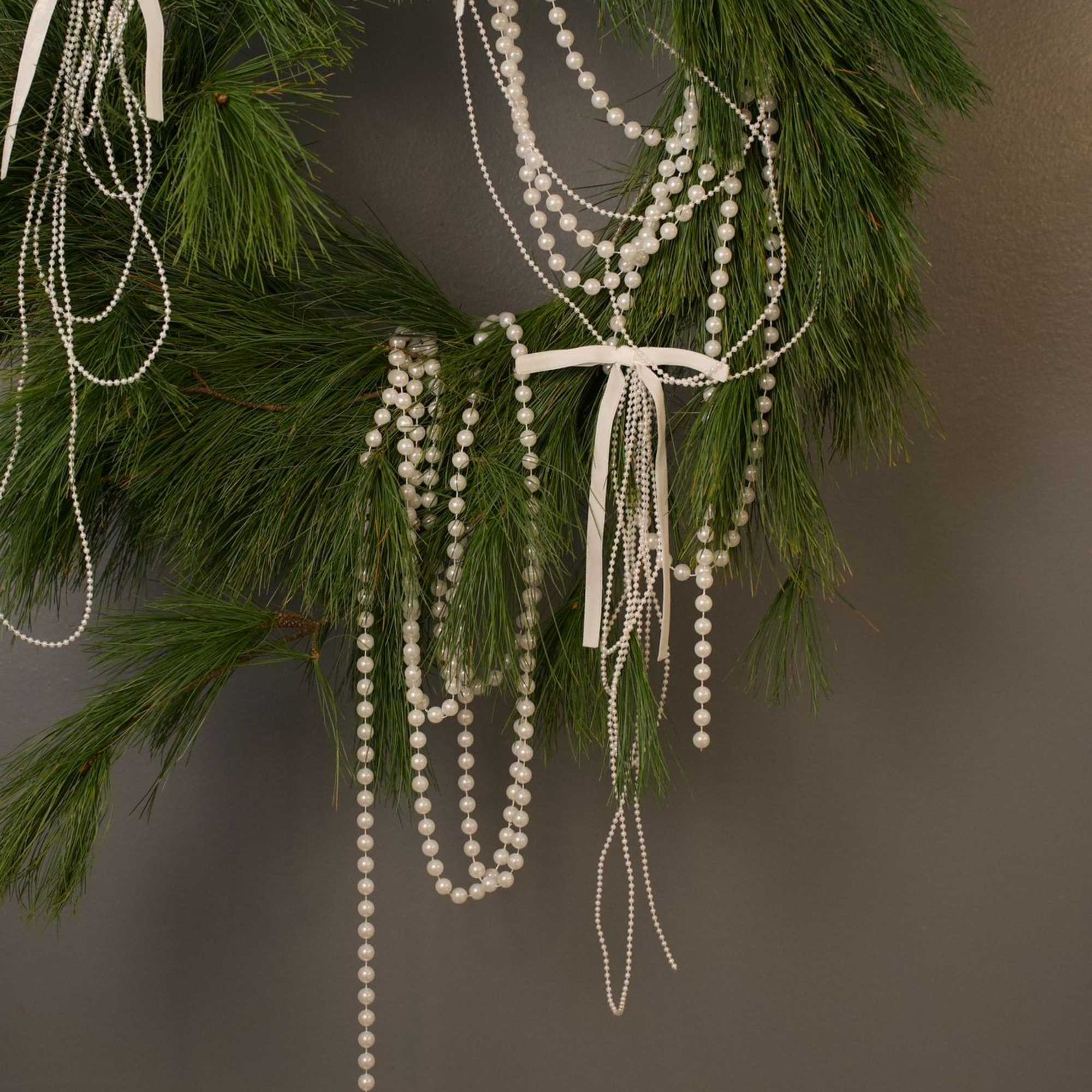 A modern winter wreath crafted from fresh long-needle pine and styled with