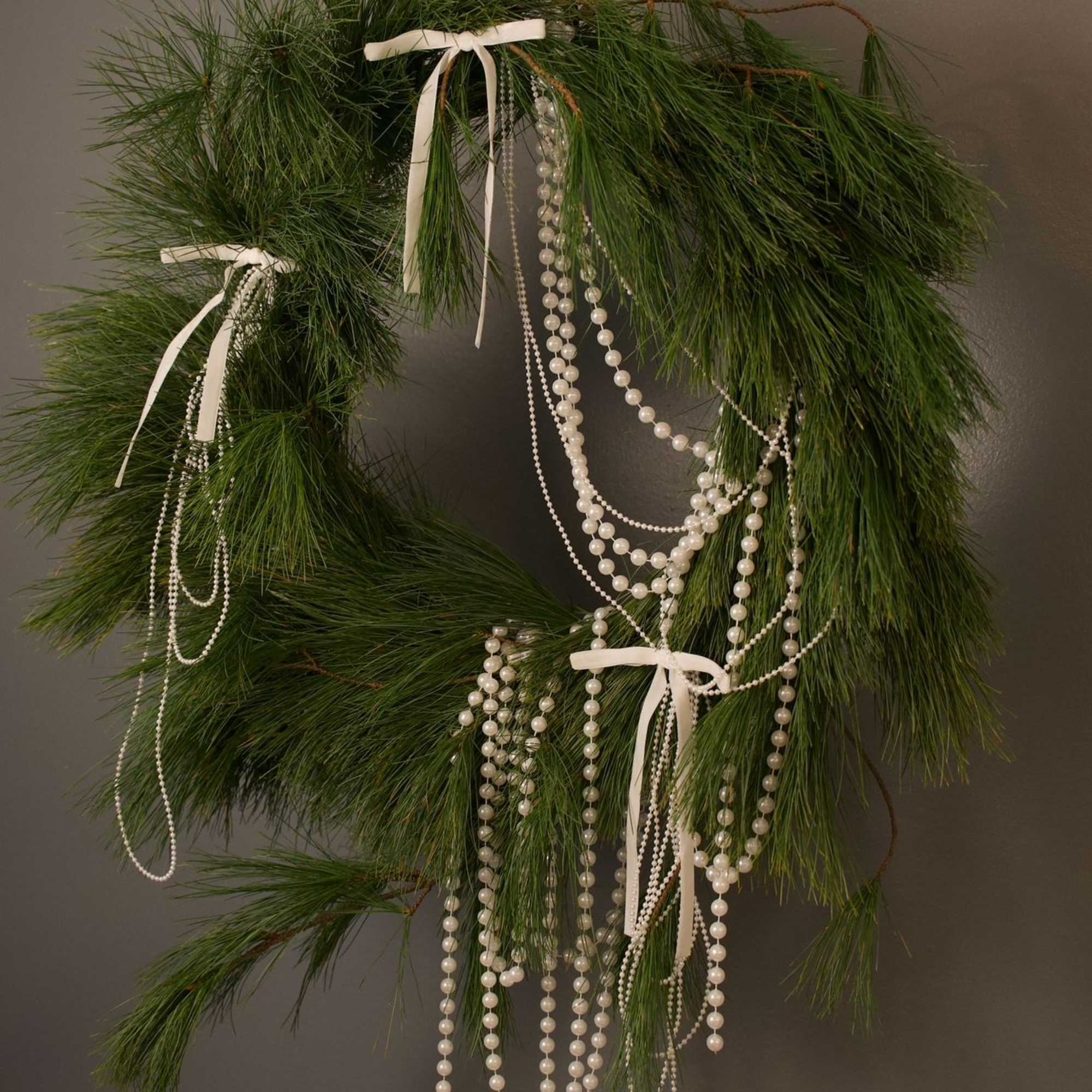 A modern winter wreath crafted from fresh long-needle pine and styled with