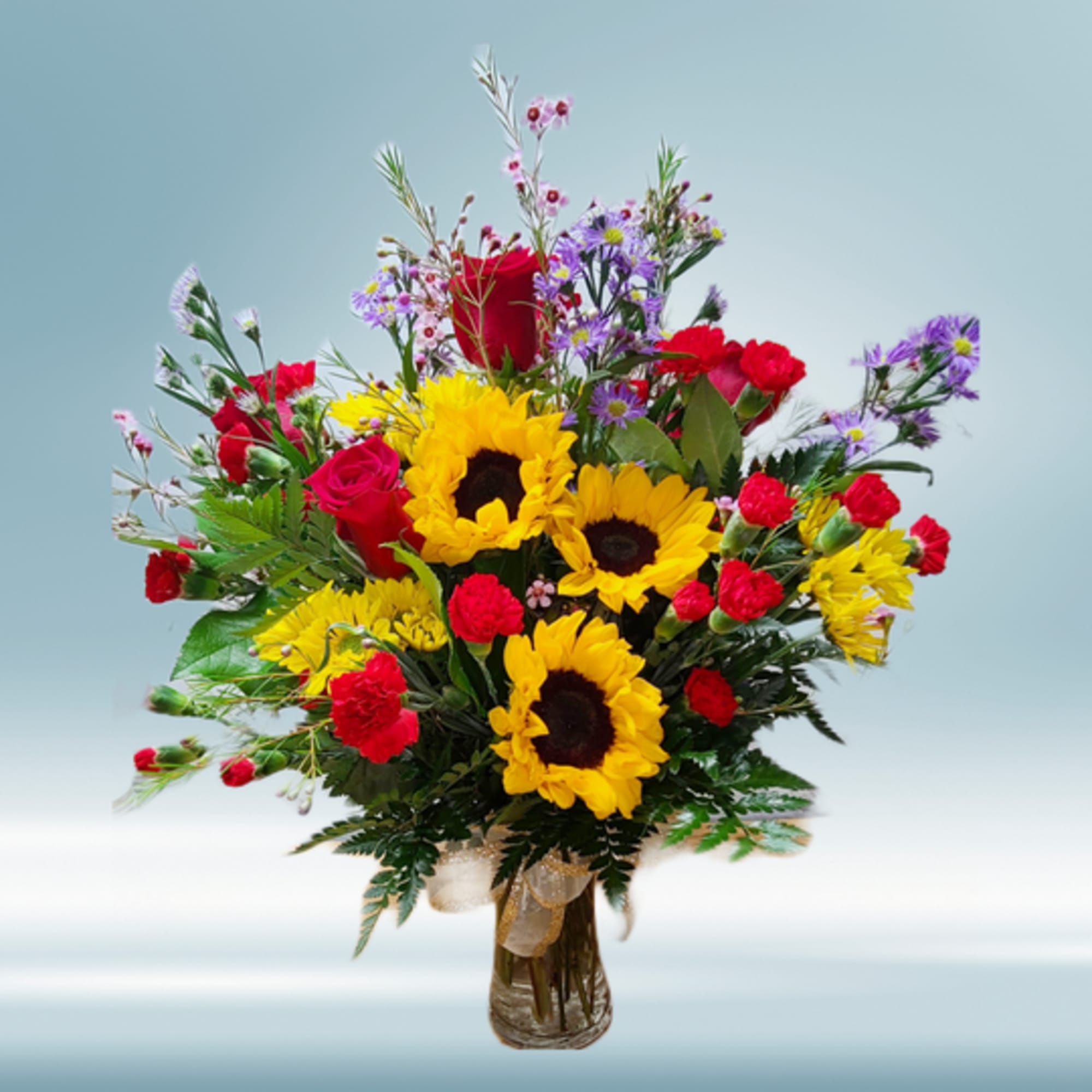 A fresh arrangement in a vase featuring fall colors, orange, red, and