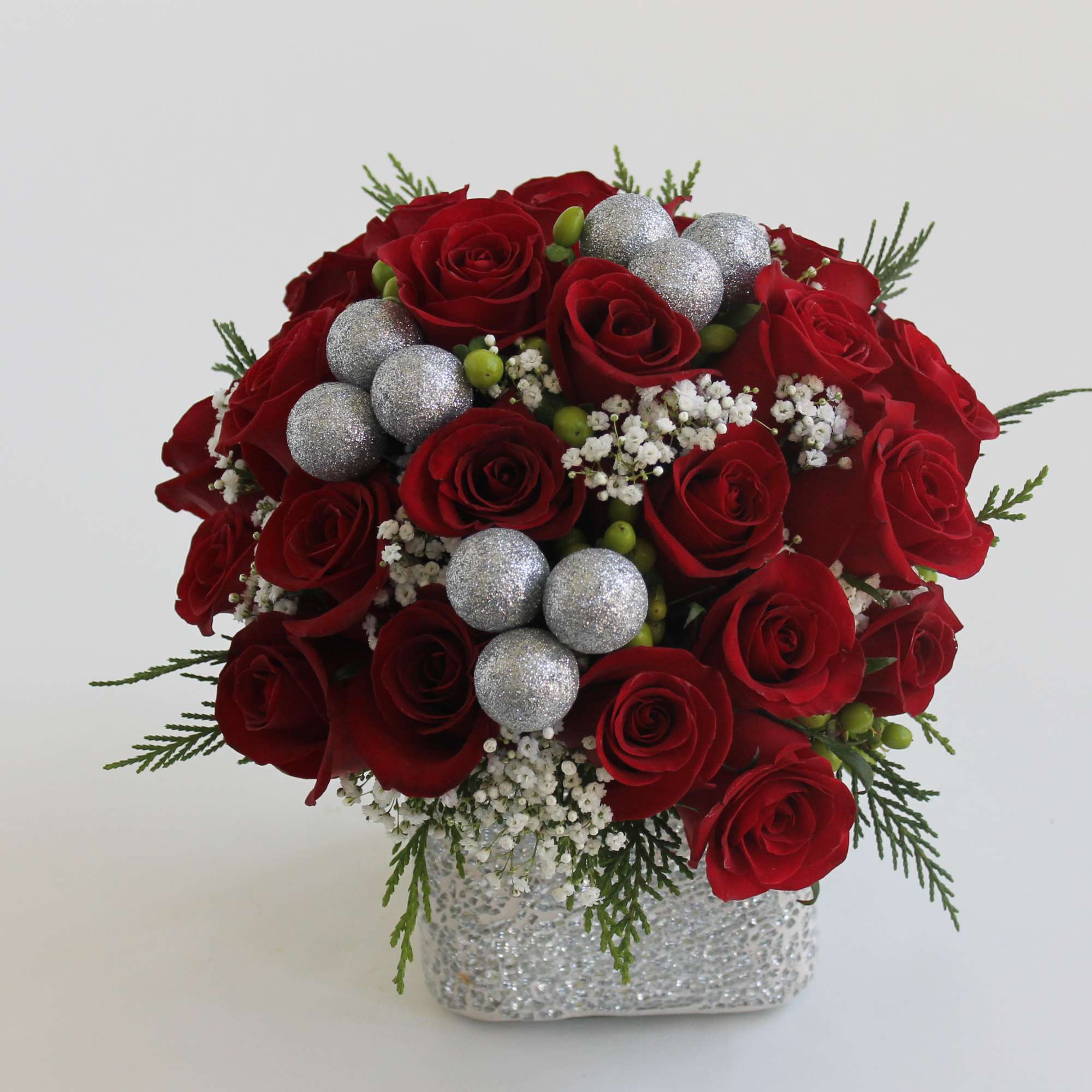Send your Christmas love with this hand-tied centerpiece of red roses, snowy