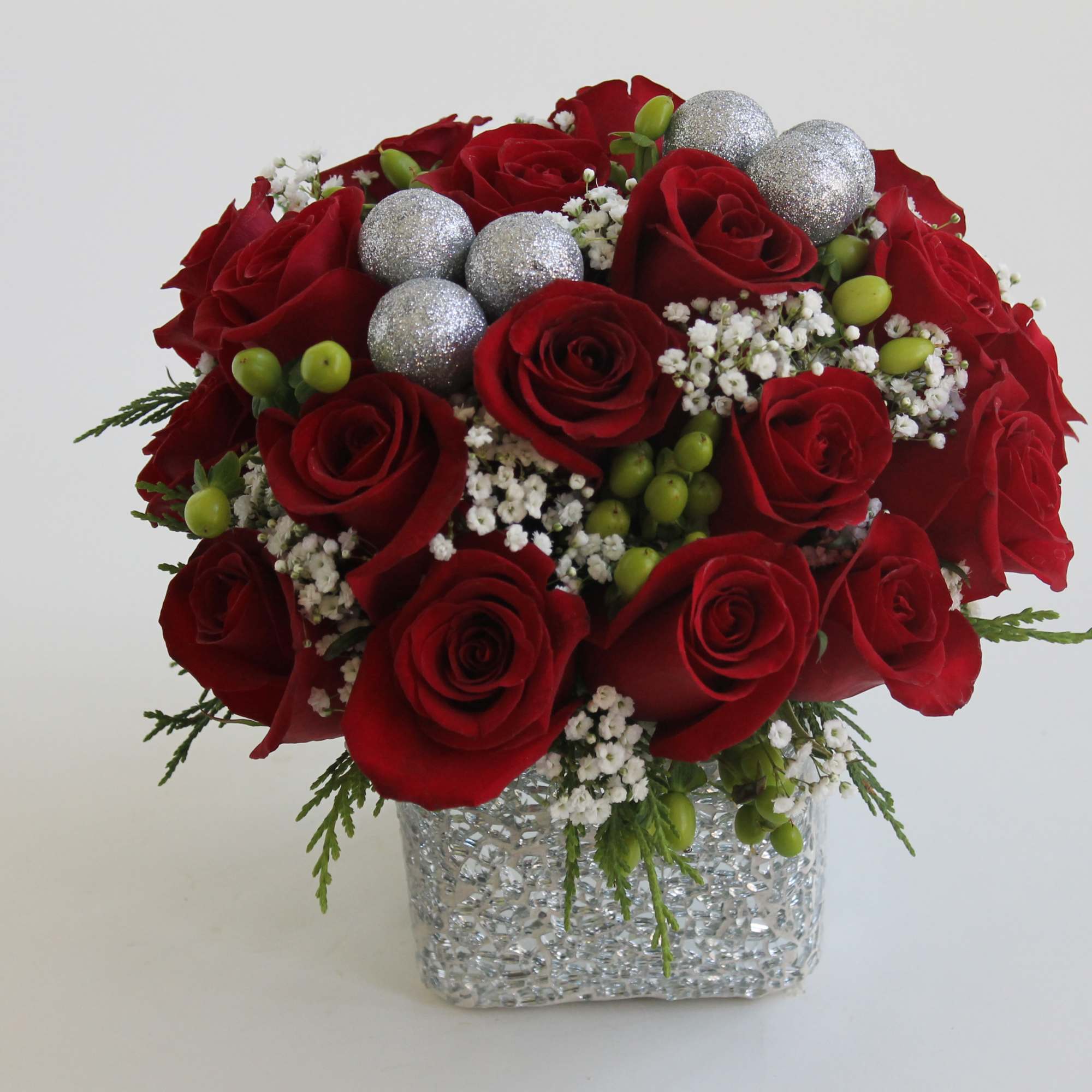 Send your Christmas love with this hand-tied centerpiece of red roses, snowy