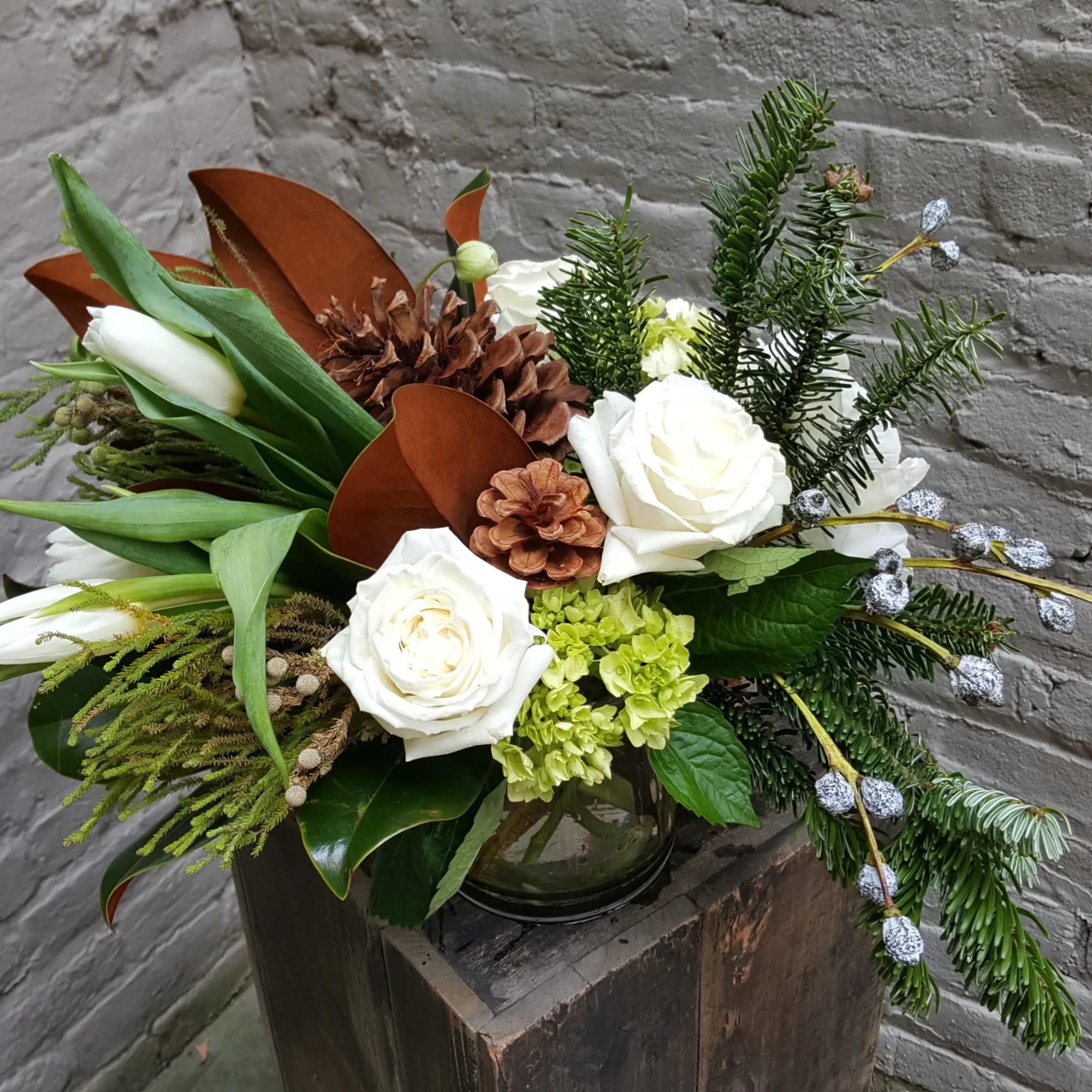 A clear glass vase filled to the brim with a collection of