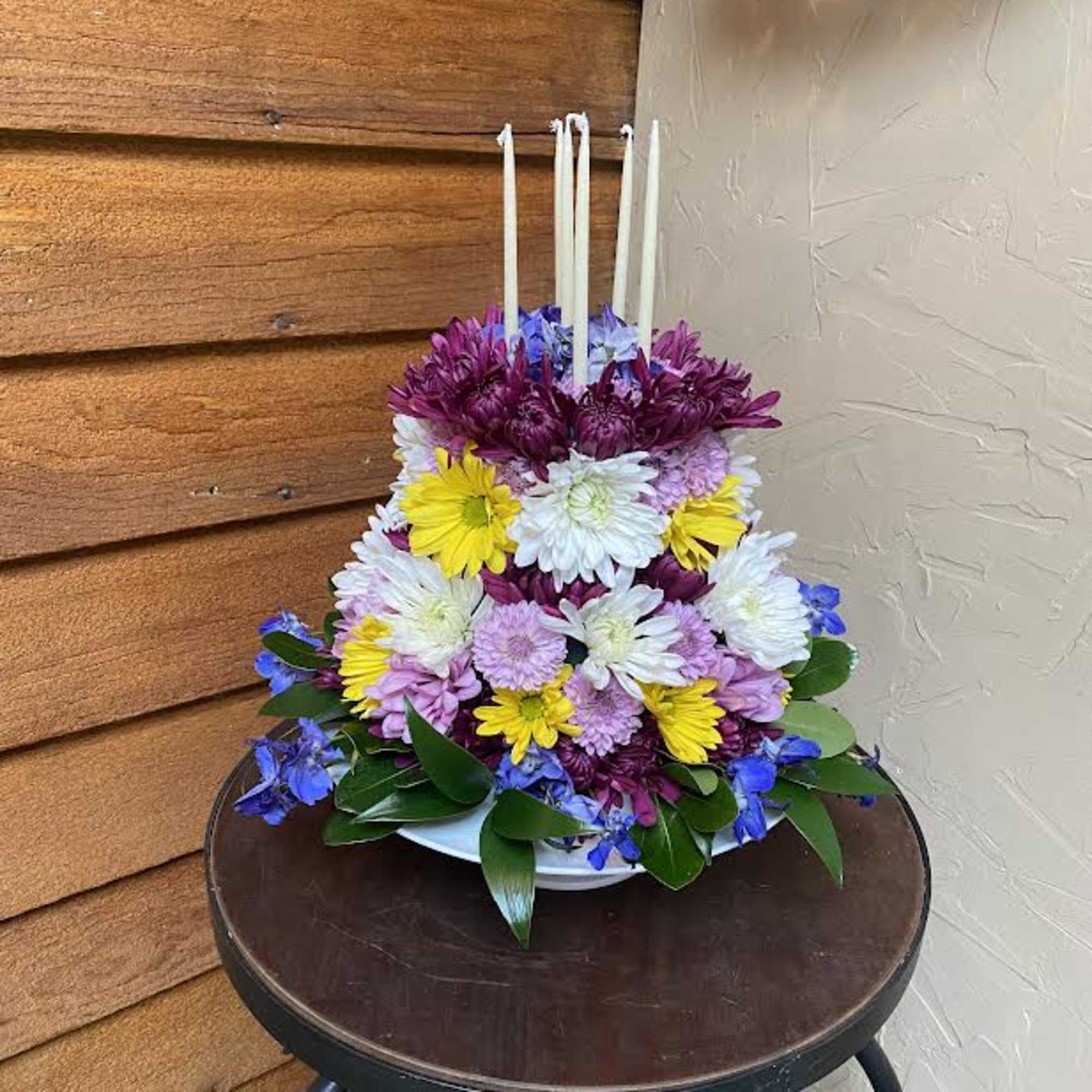 Adorable way to celebrate any occasion. Designer selected flowers. 6 Candles included.