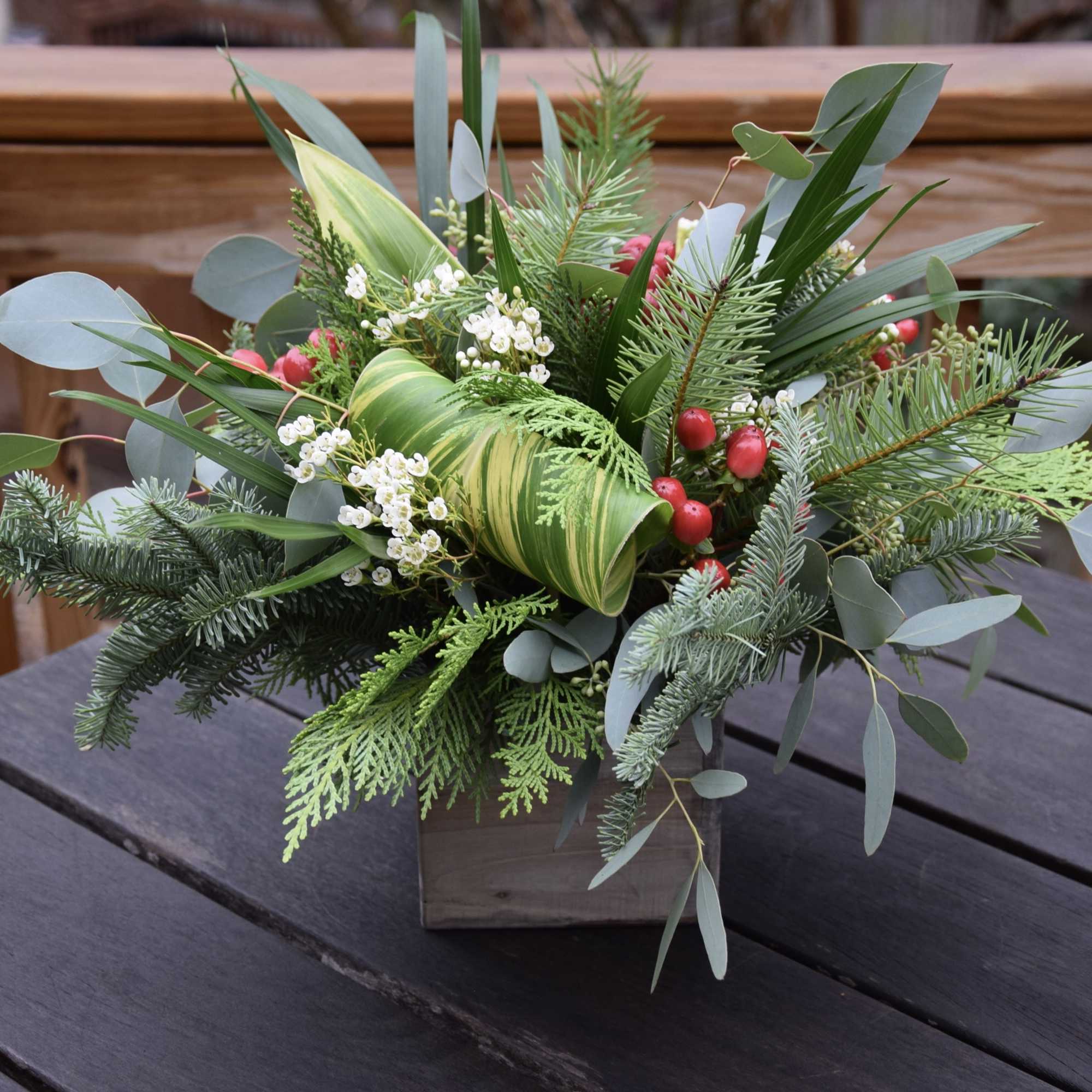 A festive winter flower arrangement in a 5inch wooden box with a