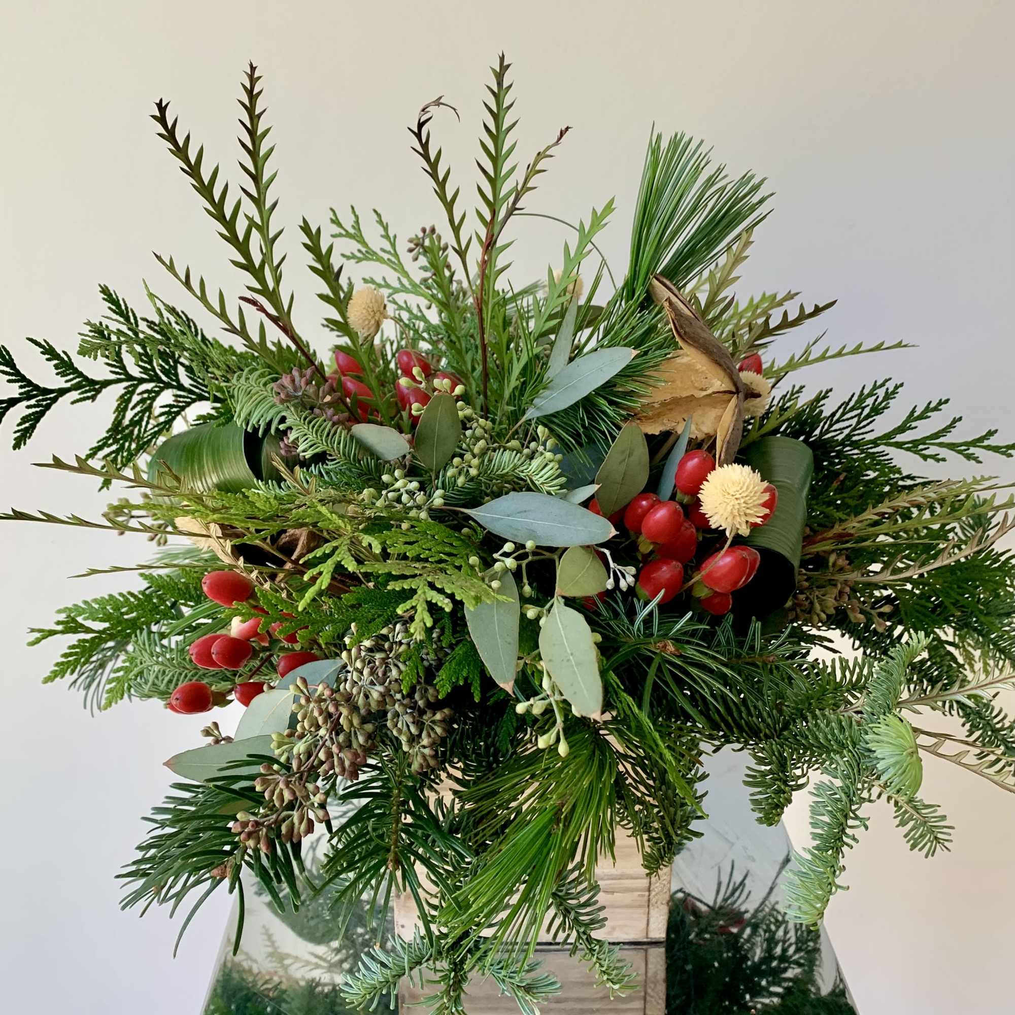 A festive winter flower arrangement in a 5inch wooden box with a