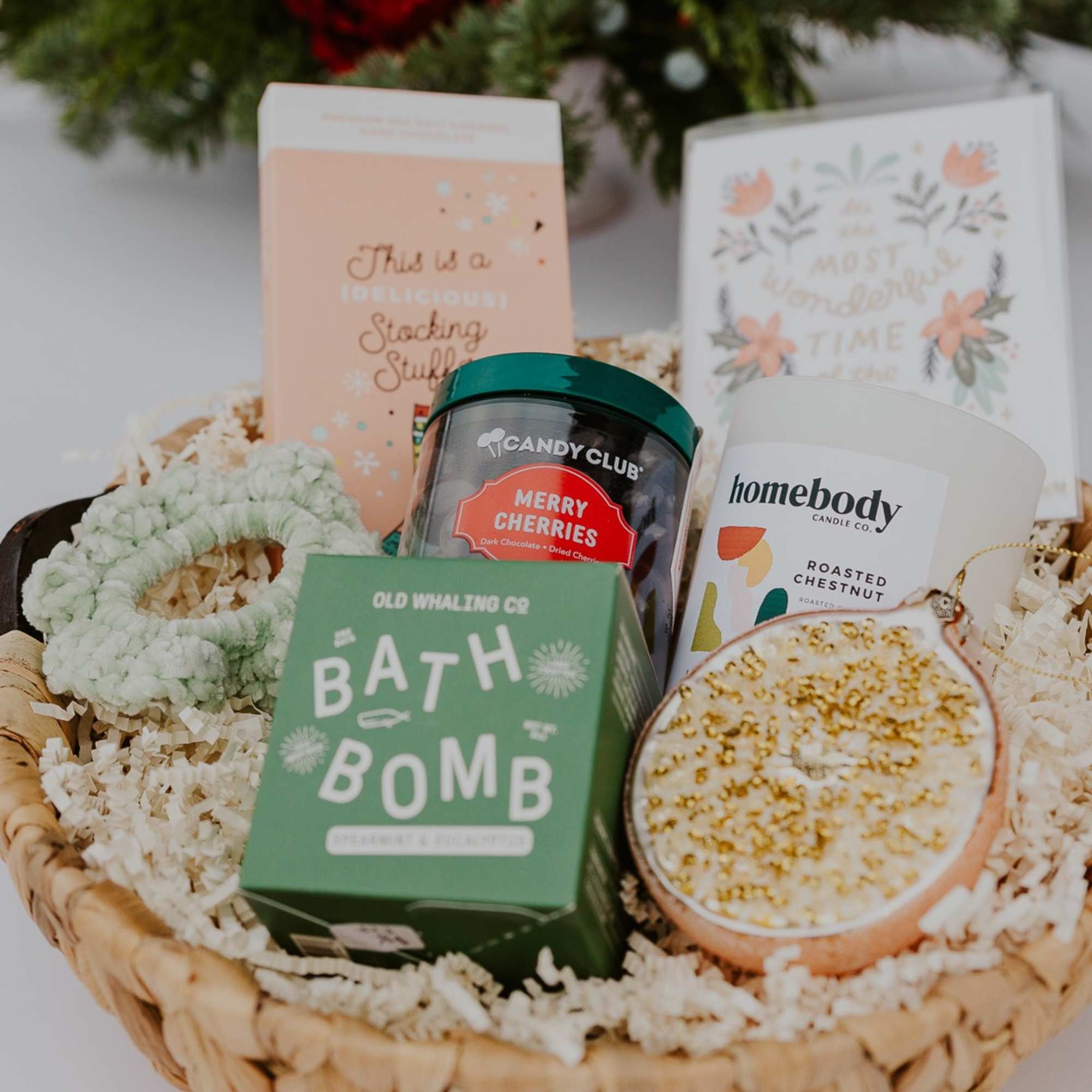 The Holiday Gift Basket includes a bath bomb, holiday scent candle, face