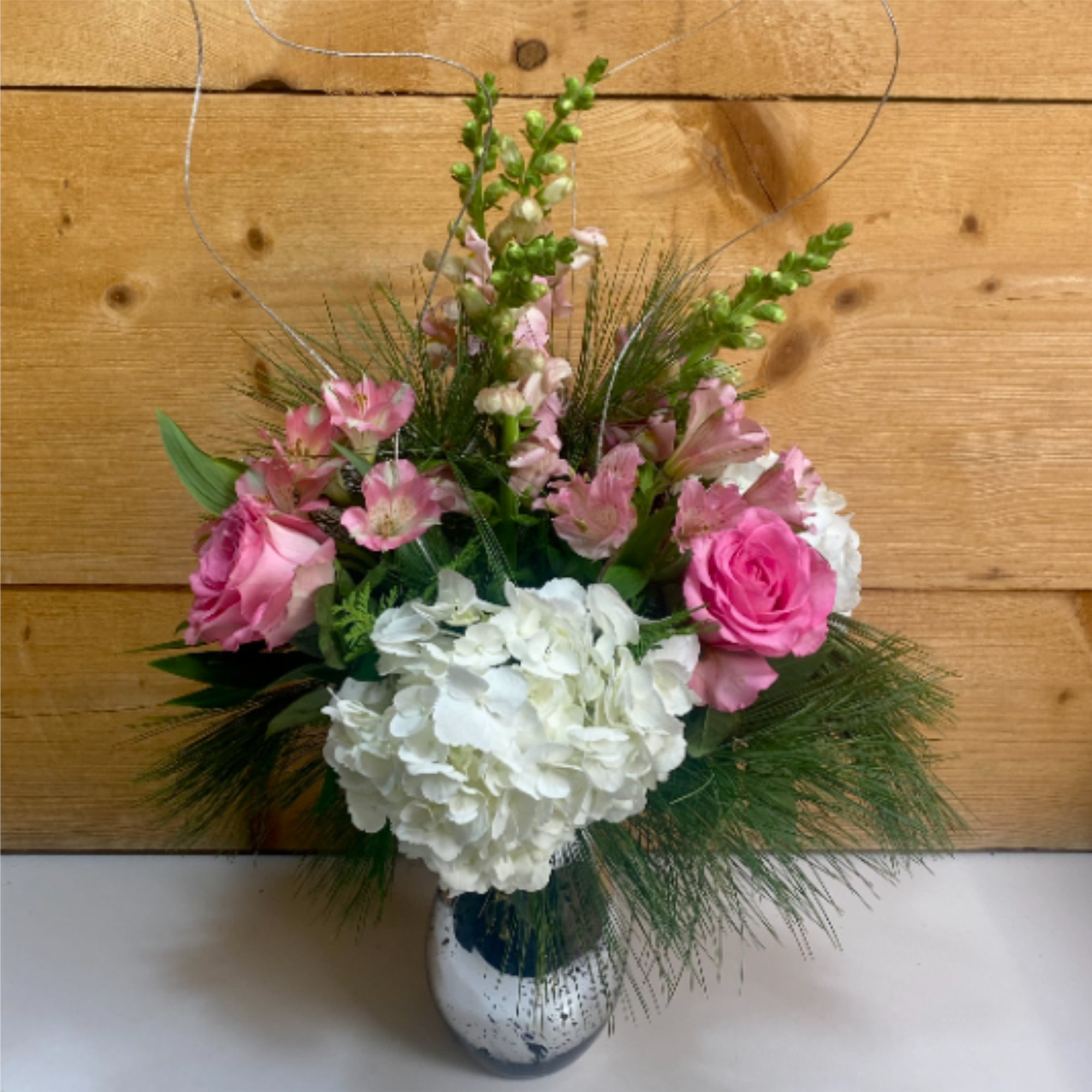 The Pretty in Pink Holiday Bouquet is a charming arrangement that combines