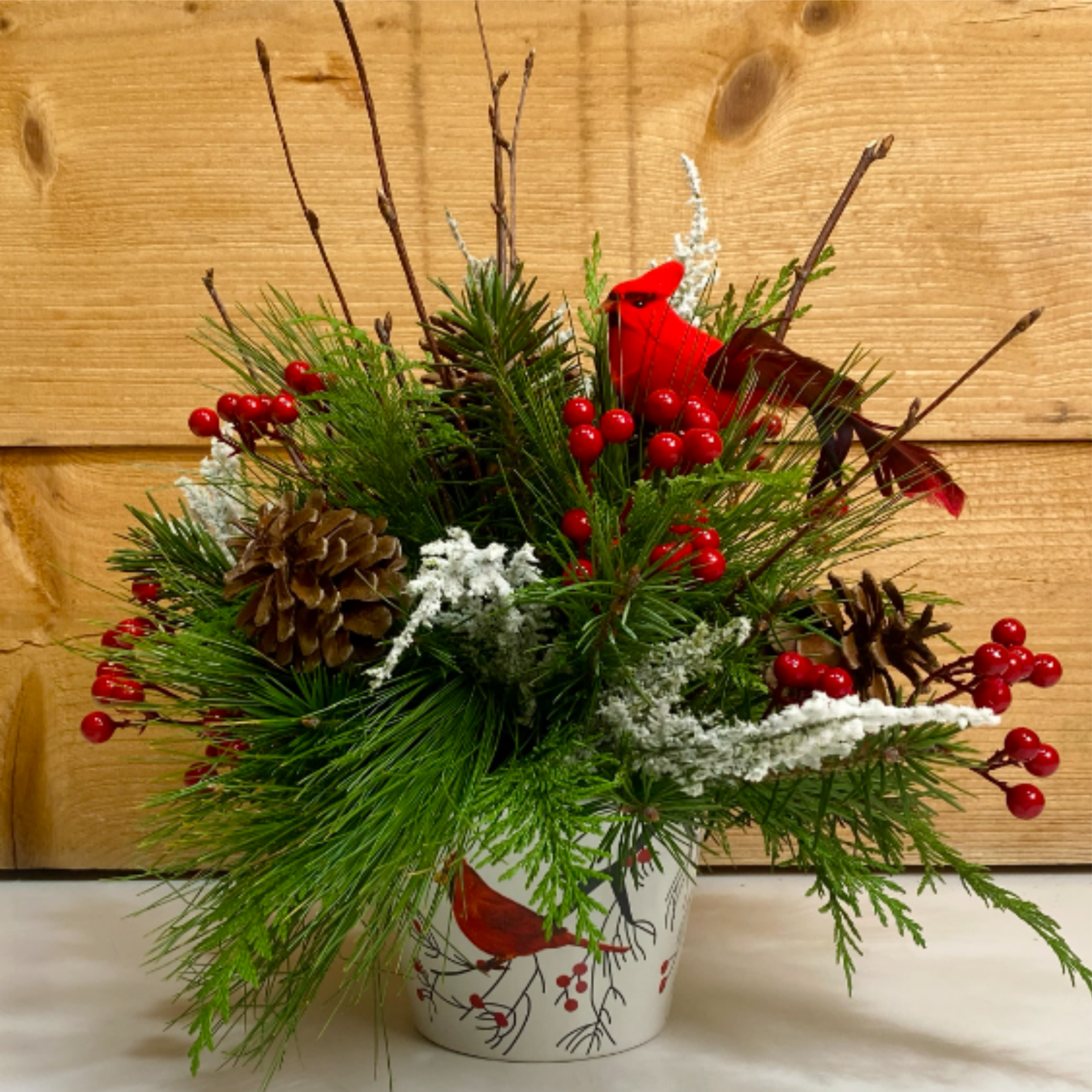Cardinal Christmas is a delightful arrangement for the winter season, with a