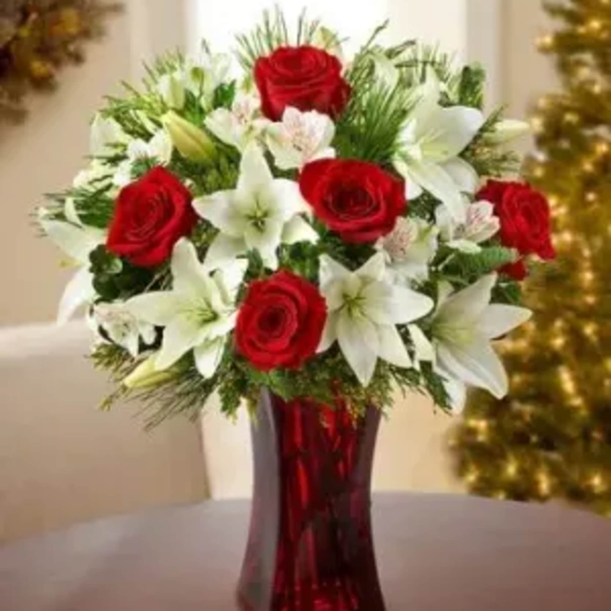 Our enchanting bouquet of red roses, white lilies, alstroemeria and evergreens delivers