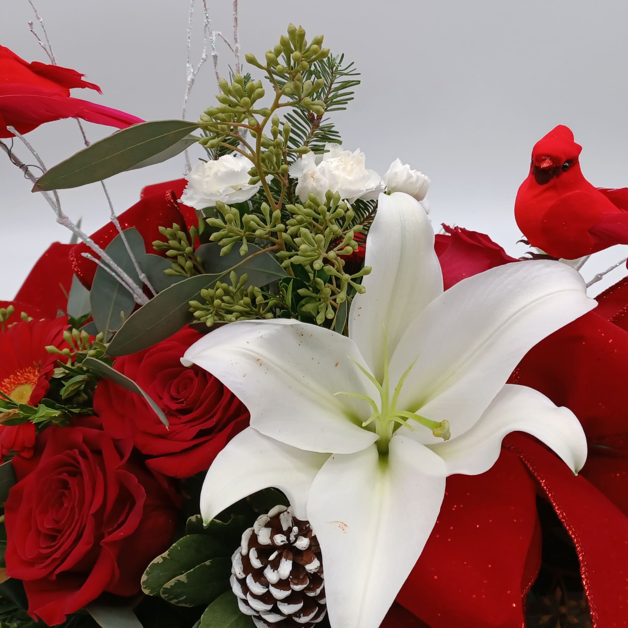 A mix of evergreens and selected flowers such as Hybrid White Lilies