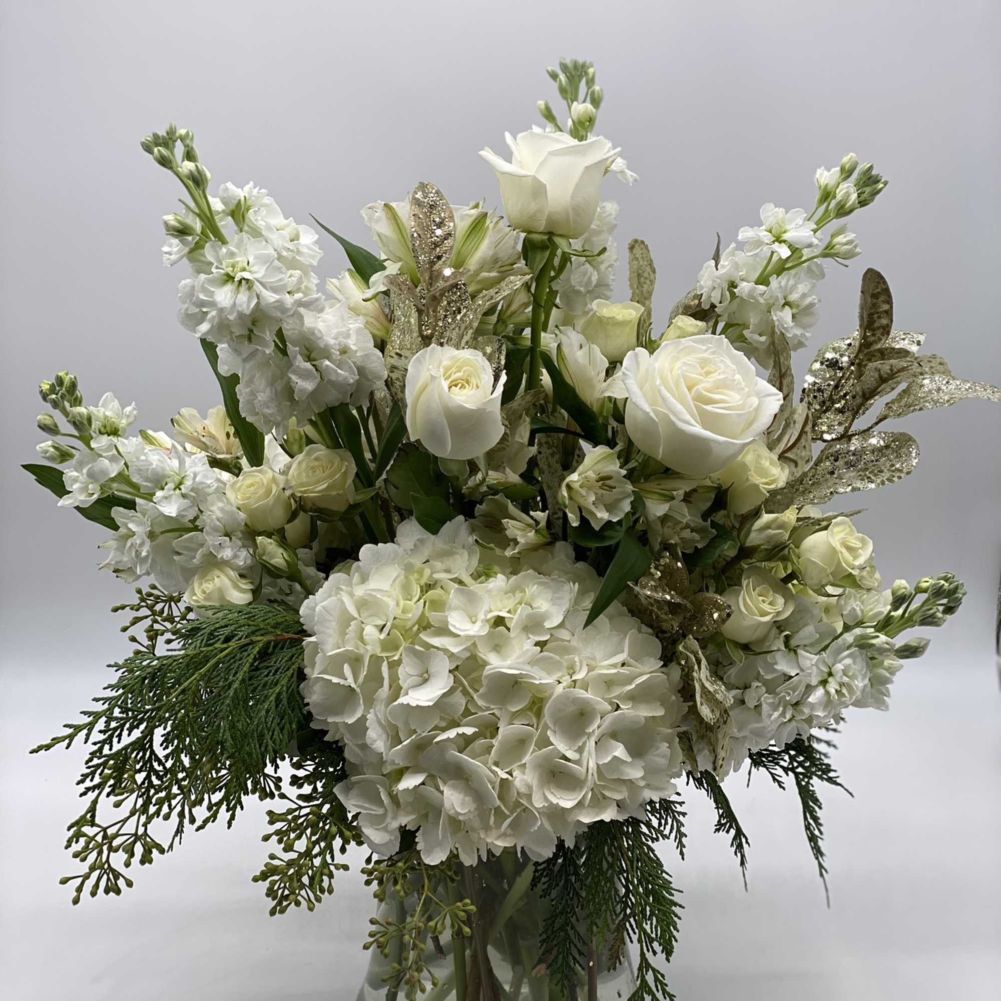 This elegant arrangement is adorned with a seasonal mix of flowers.
With soft