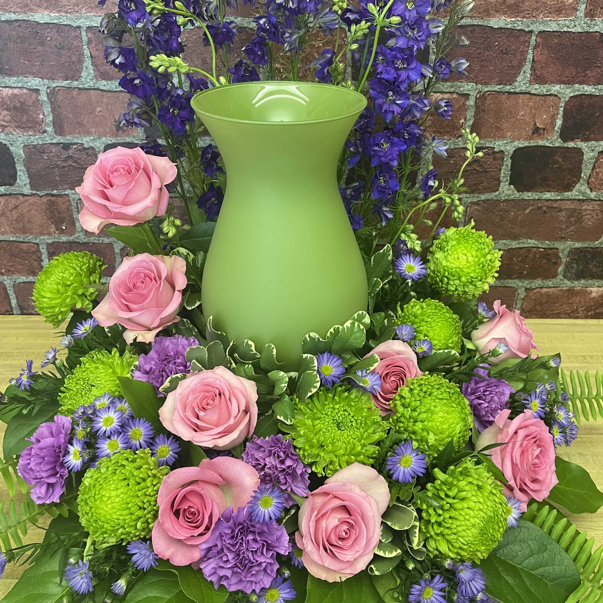 Beautiful mix of pink, purple, and green flowers will surround your loved