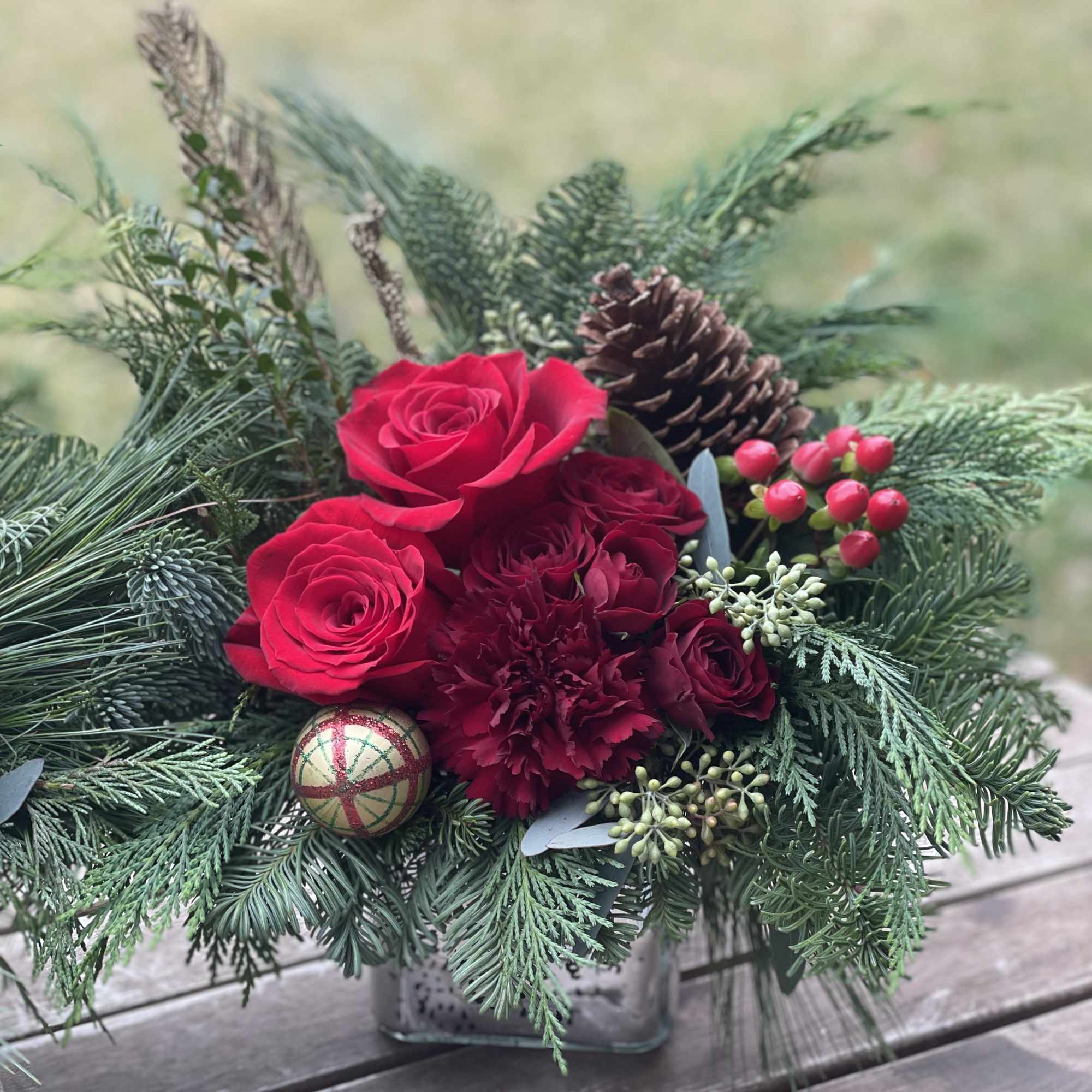 Petit winter greenery with a touch of reds and a few decorative