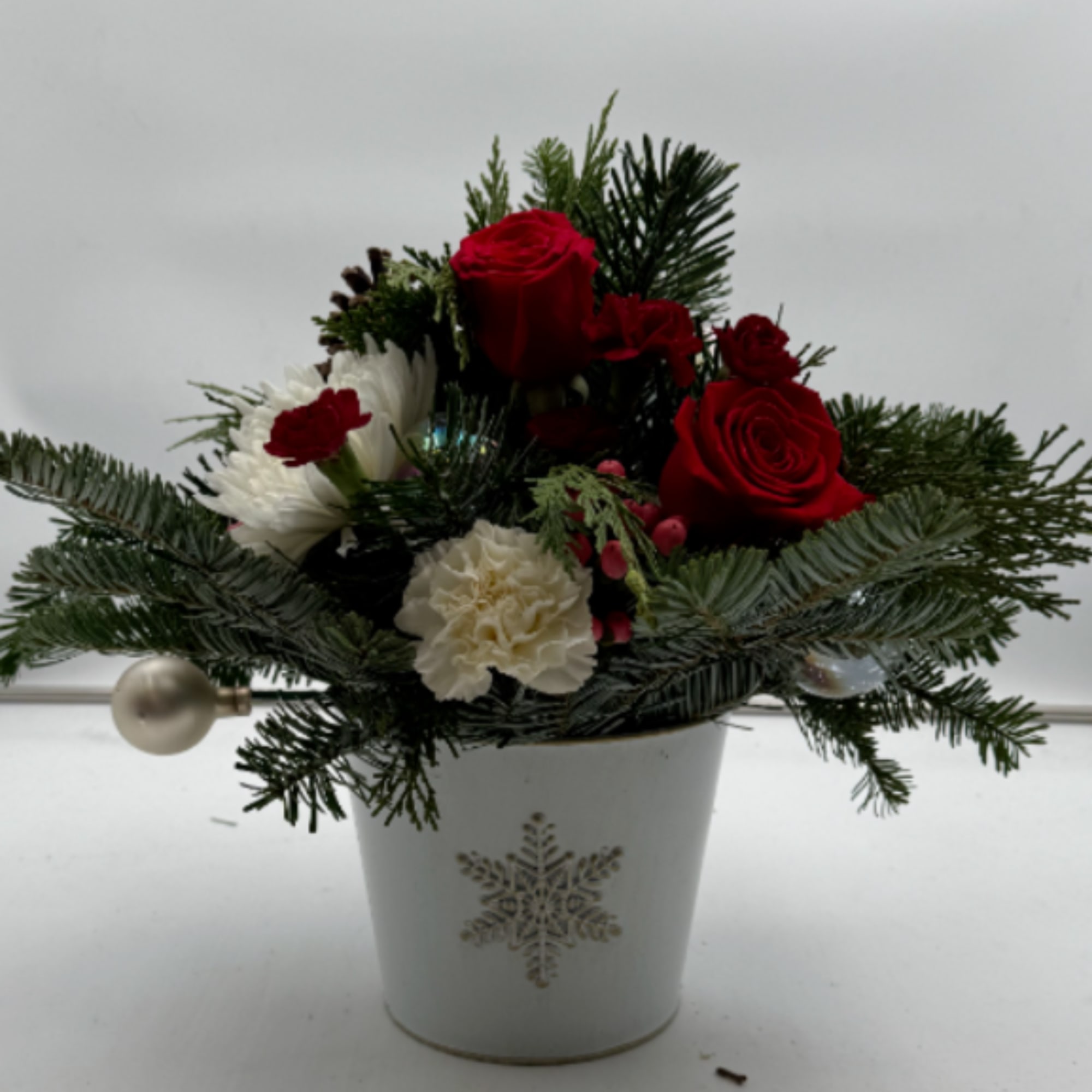 This arrangement is in a holiday keepsake metal pot, filled with Red