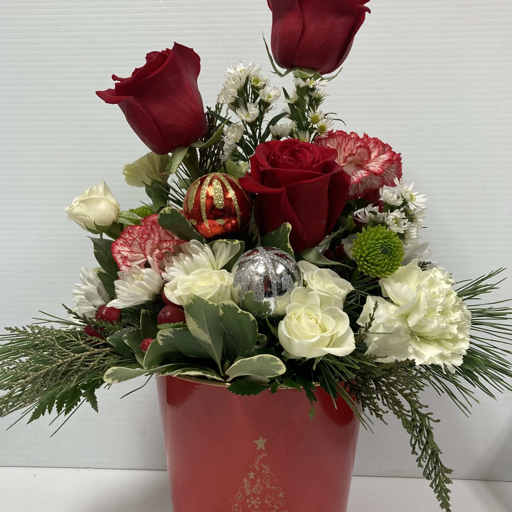 Holiday arrangement in a cute red metal pot with Christmas tree on