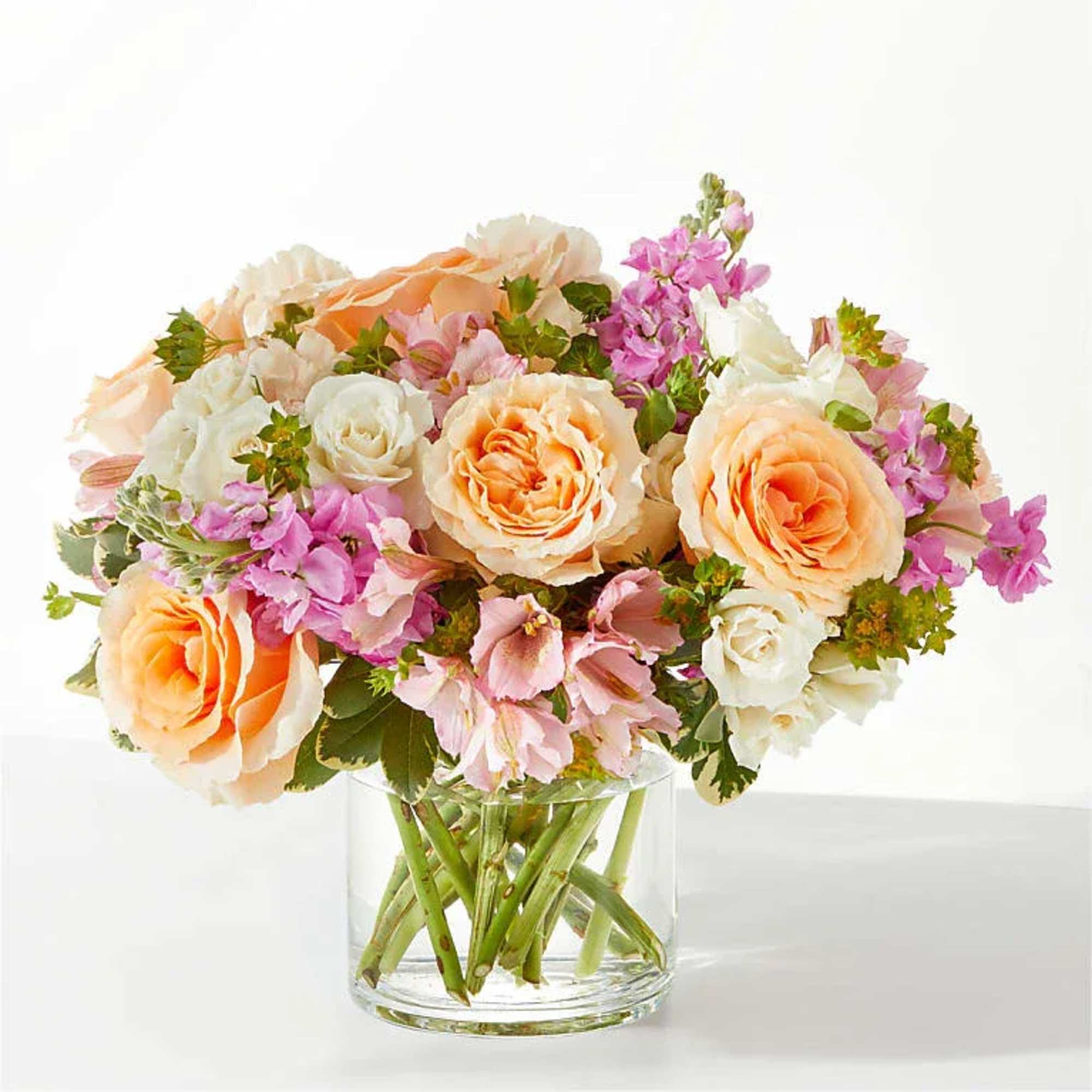 Vase Arrangement Of Stock, Roses, Spray Roses, Alstromeria, Carnations And Lush Greenery.