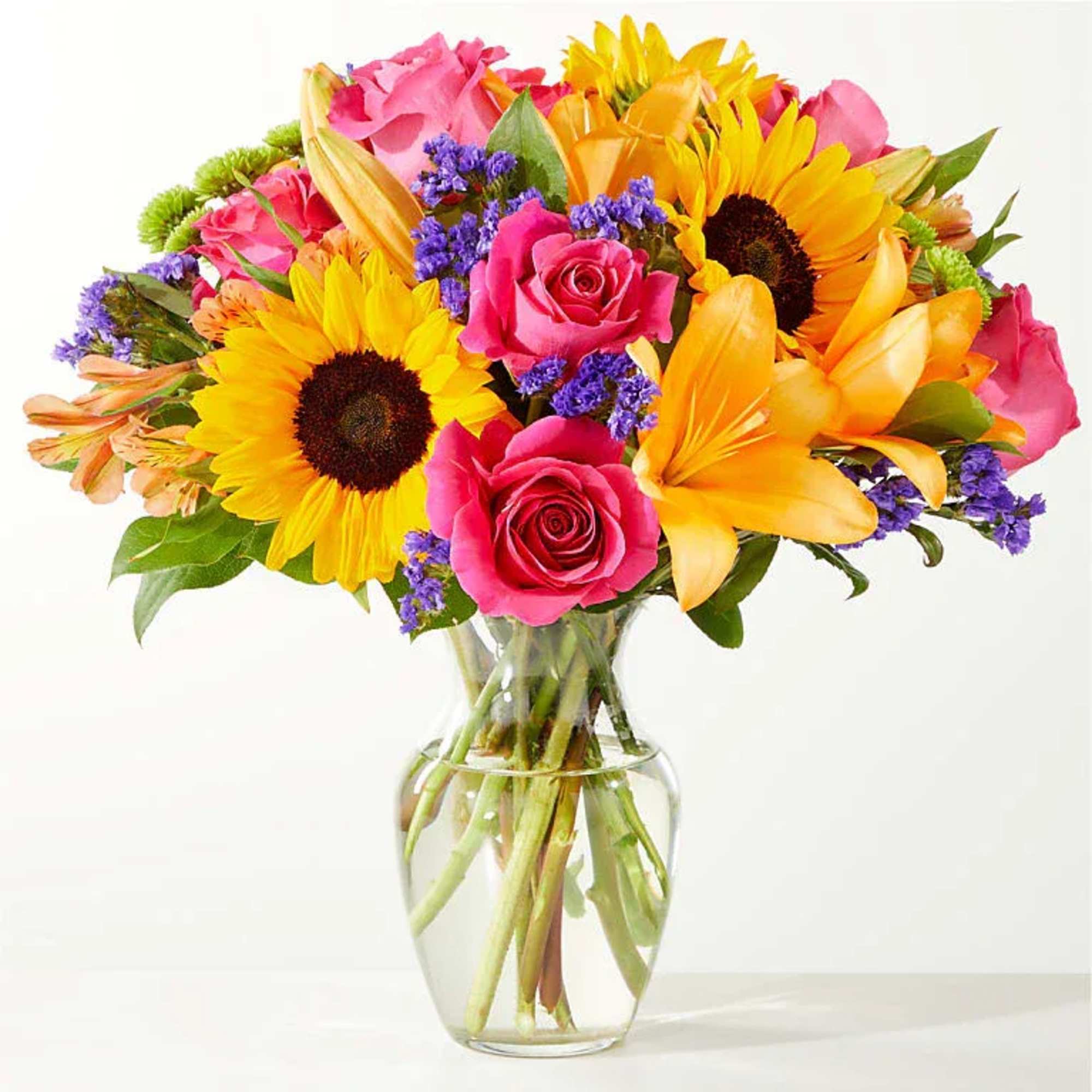 Vase Arrangement Of Lilys, Sunflowers, Roses, Buttons, Alstromeria, Statice And Lush Greenery.