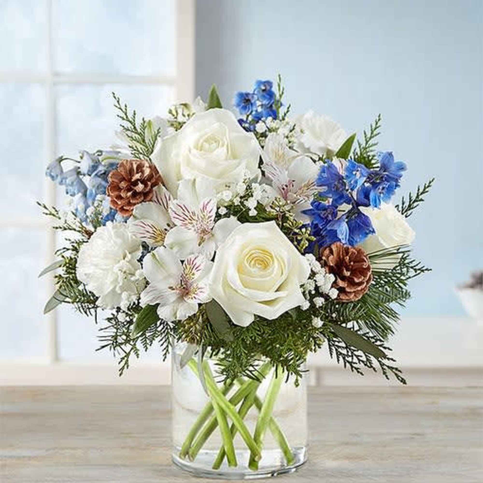 This  arrangement with white roses, carnations, and Peruvian lilies (alstroemeria); blue