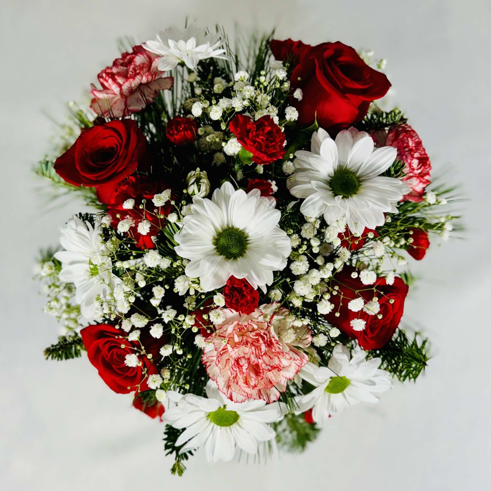 A beautiful white Cube with Roses, Carnations, Daisies and Christmas greens.

12" Tall
12"