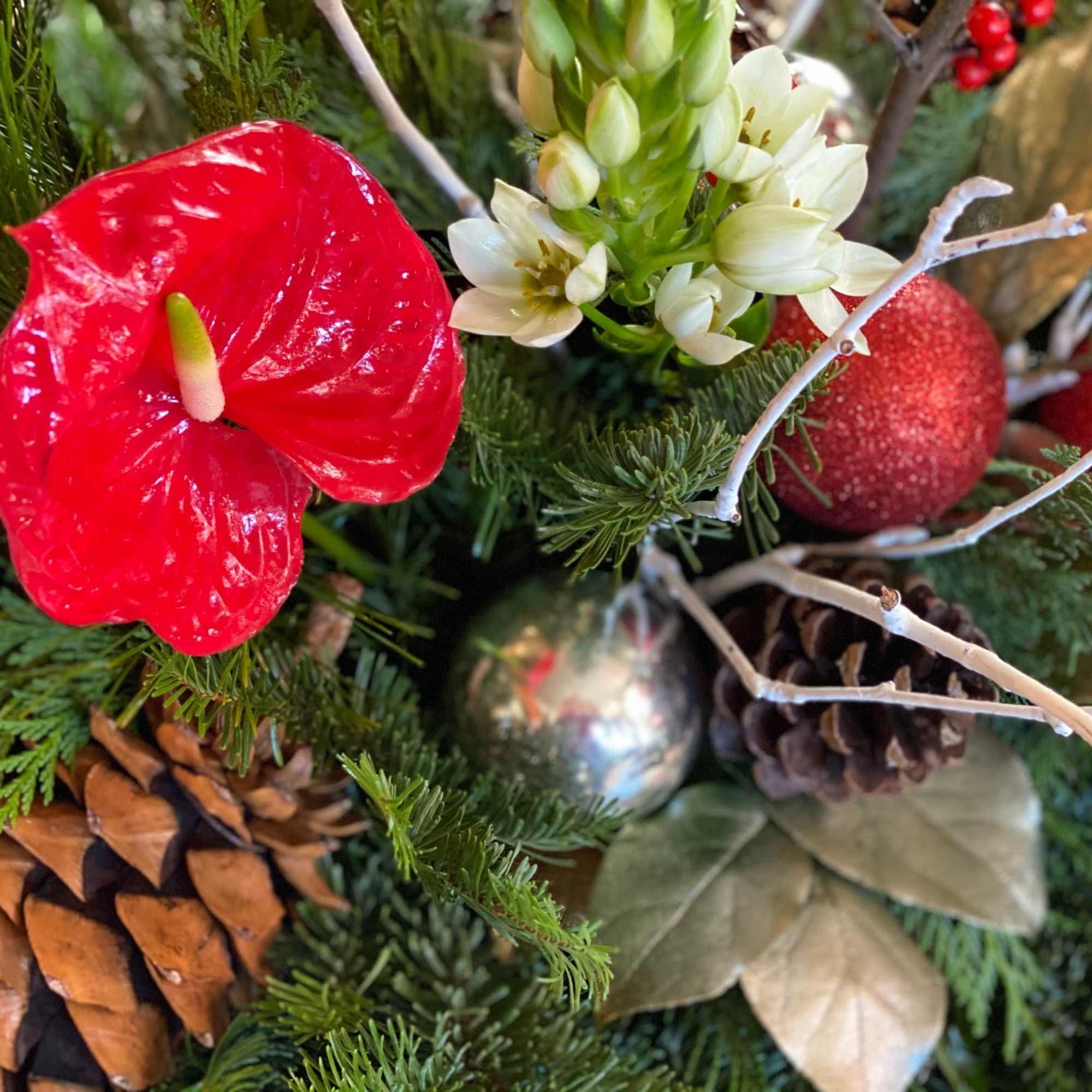 Evergreen boughs, holly, winterberry, Christmas ornaments, and a mix of tropical and