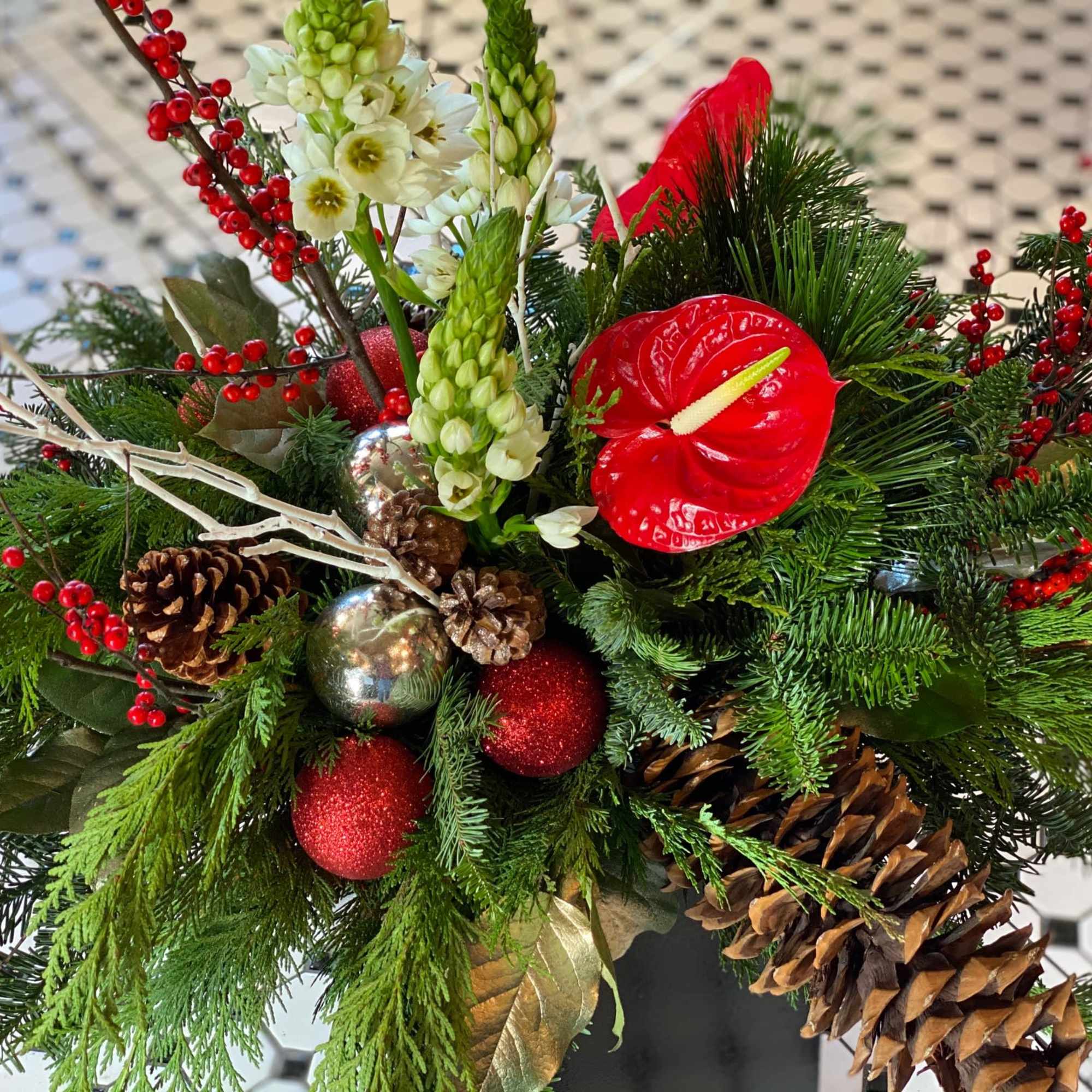 Evergreen boughs, holly, winterberry, Christmas ornaments, and a mix of tropical and