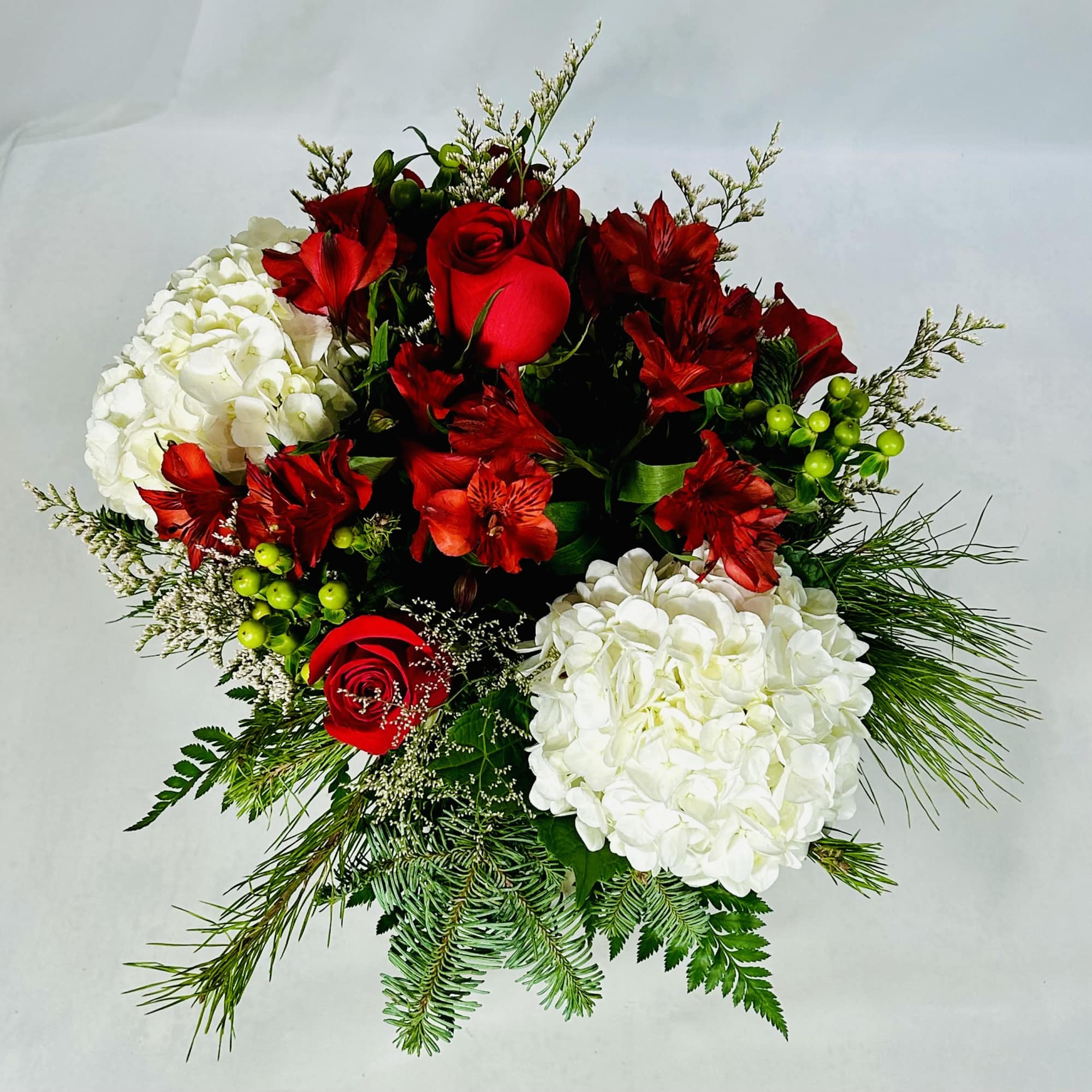 Splendid arrangement of roses, white hydrangeas, red alstroemeria and other flowers including
