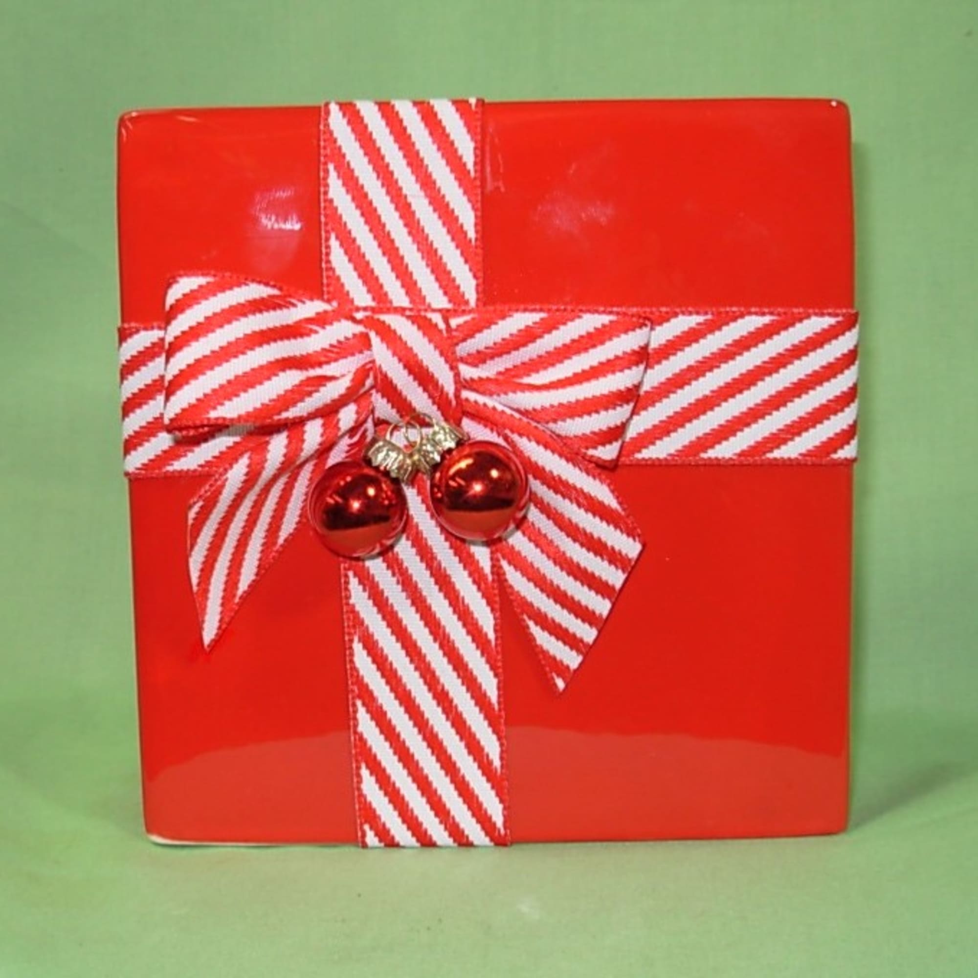 Our CHRISTMAS PACKAGE ARRANGEMENT comes arranged in a bright red ceramic gift