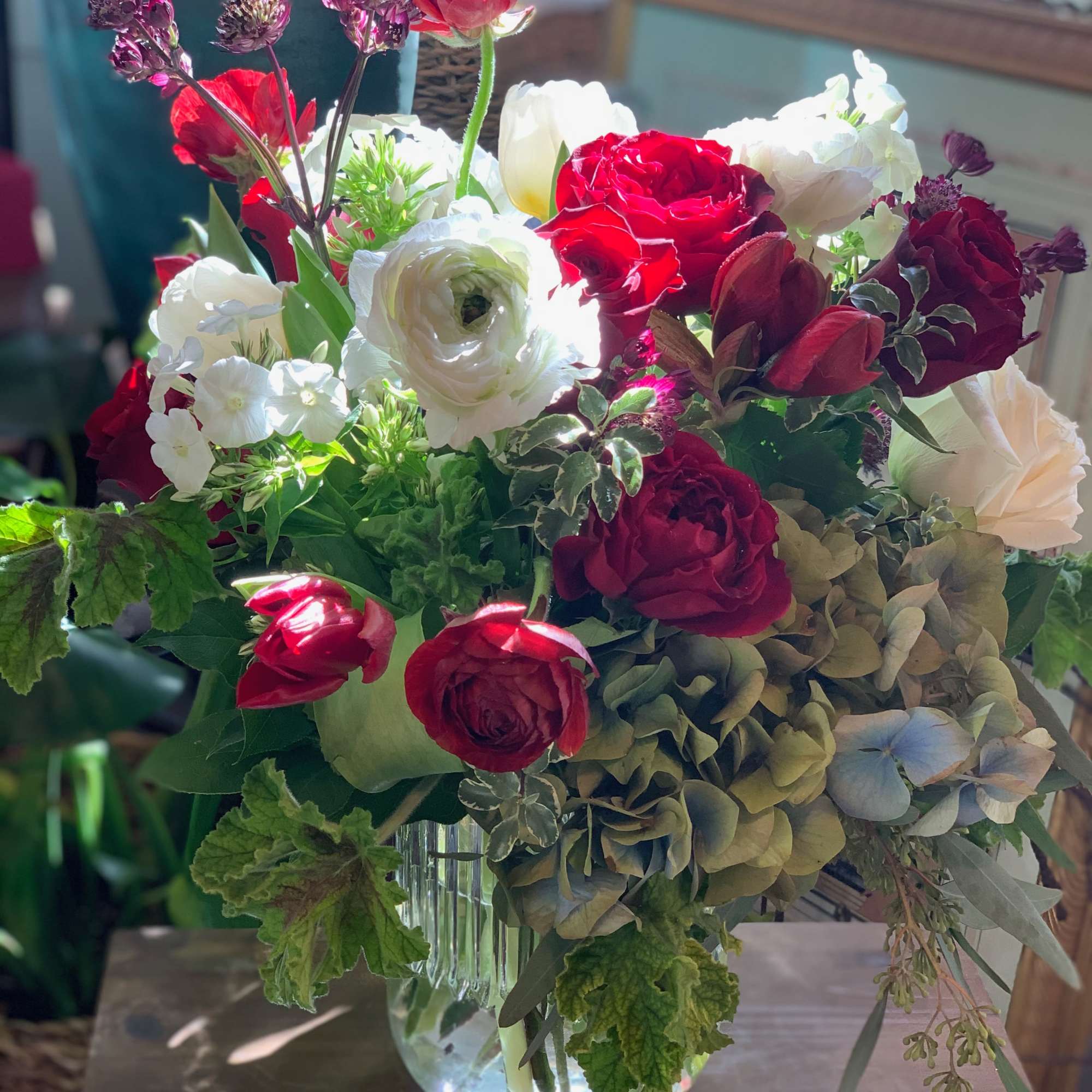 This casual and lively arrangement combines reds, whites, and other complementary colors
