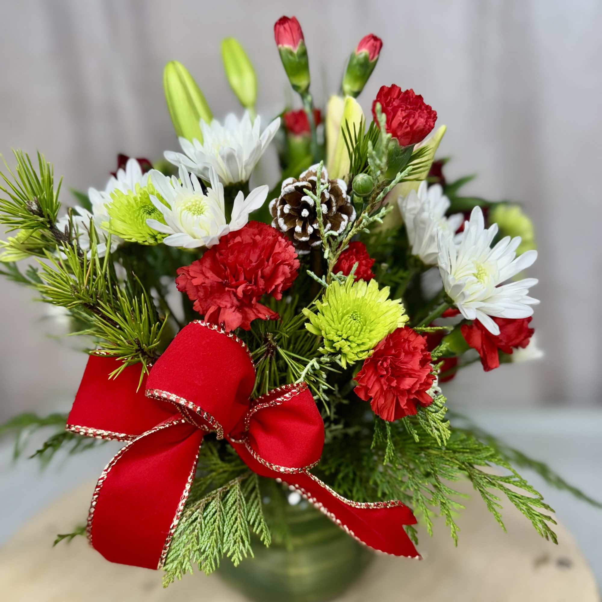 Add a touch of holiday magic with this delightful arrangement featuring lilies