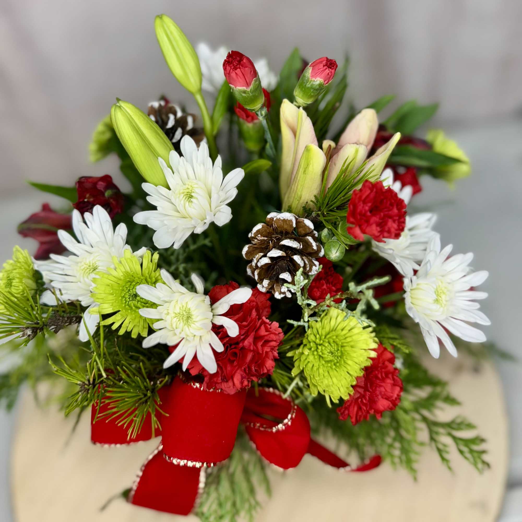 Add a touch of holiday magic with this delightful arrangement featuring lilies