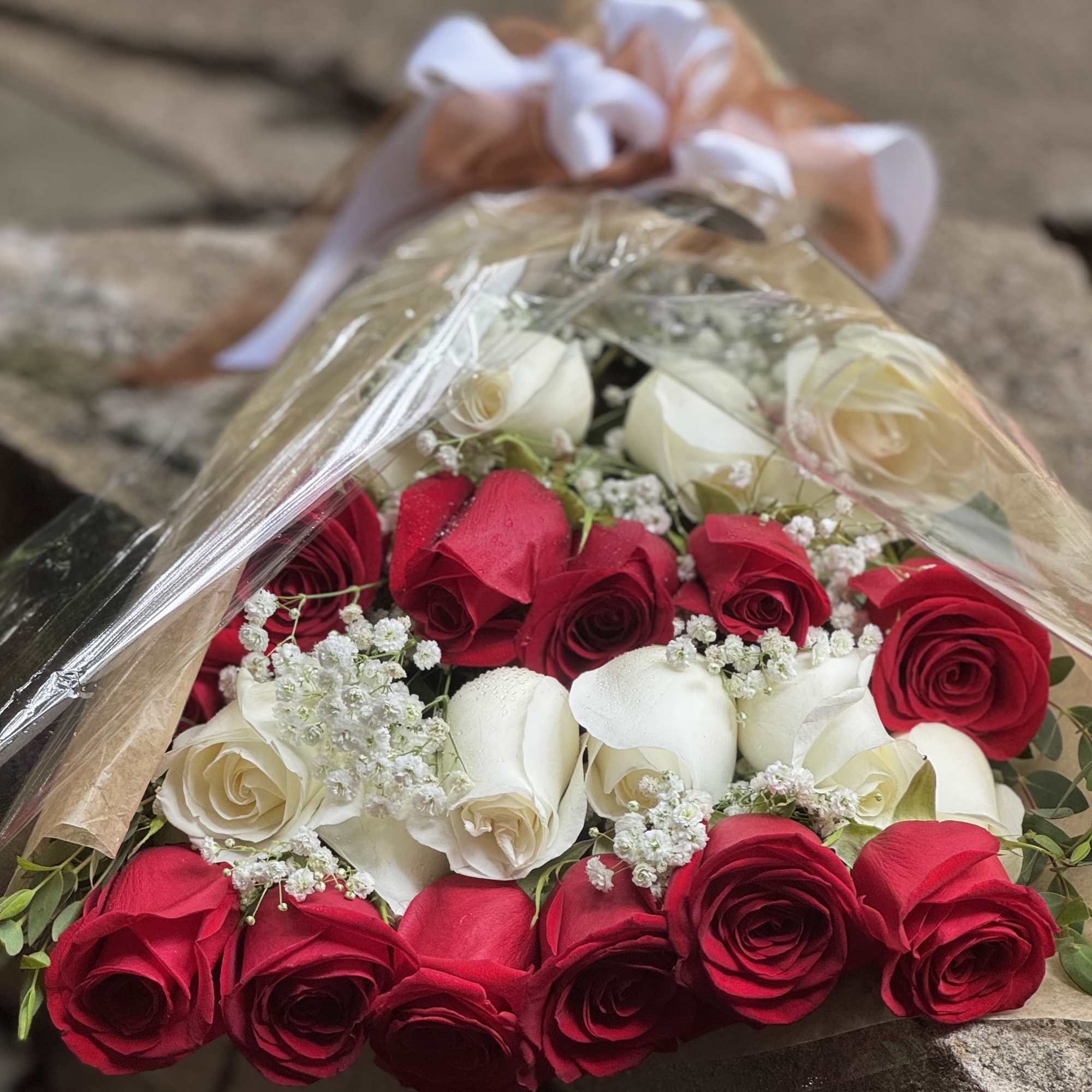 18 red and white long stem roses prepared presentation style with greens
