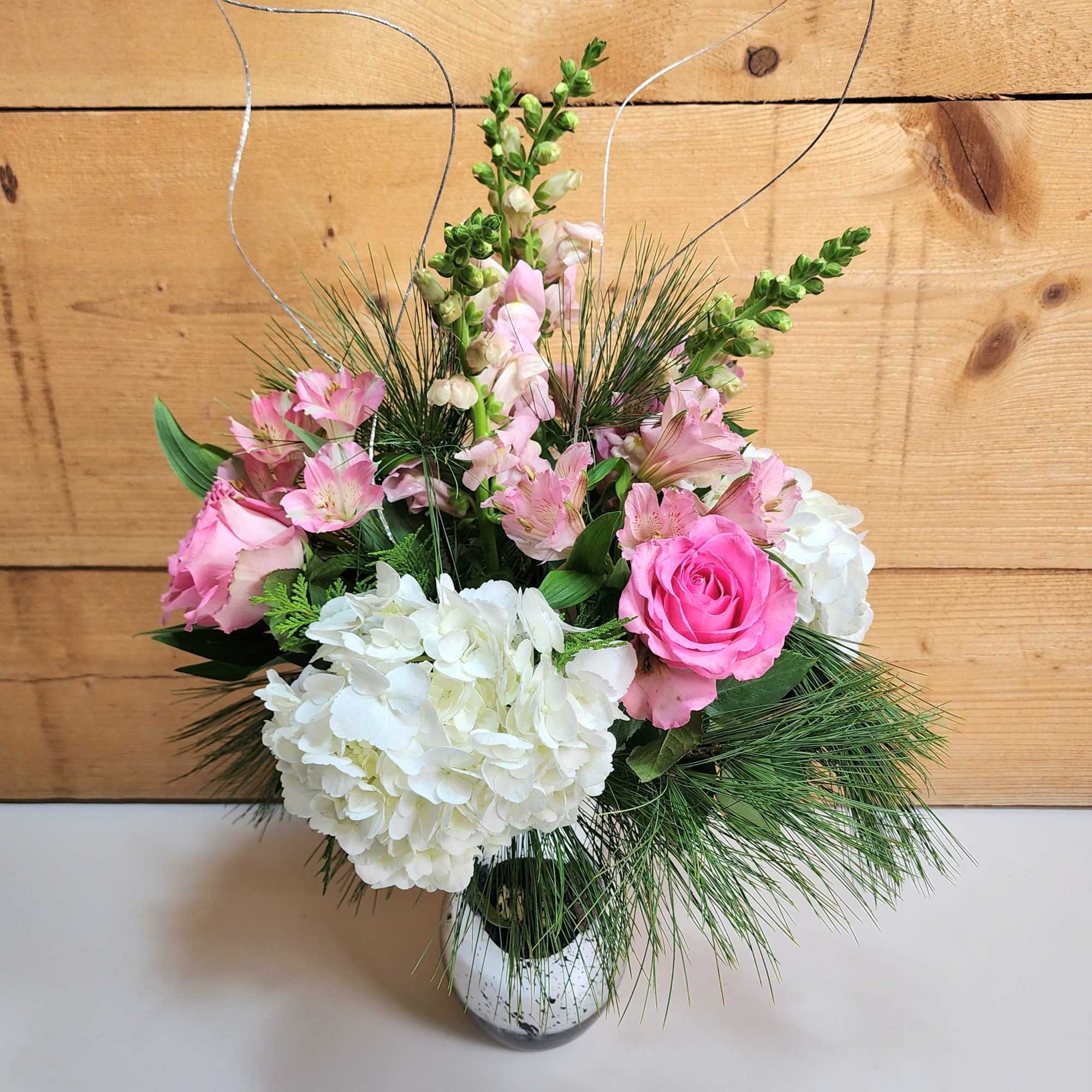 The Pretty in Pink Holiday Bouquet is a charming arrangement that combines