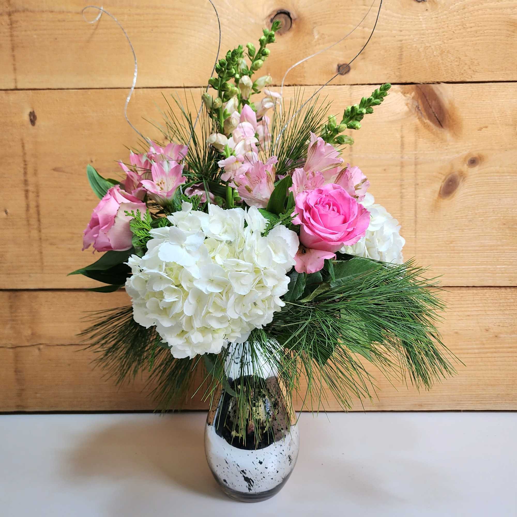The Pretty in Pink Holiday Bouquet is a charming arrangement that combines