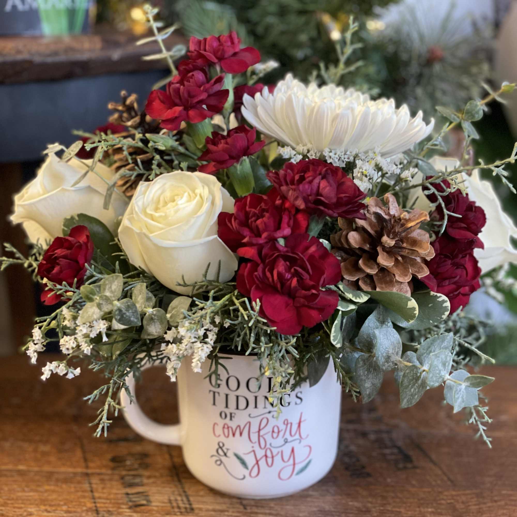 A keepsake ceramic mug featuring white roses, white cremones, burgundy mini carnations