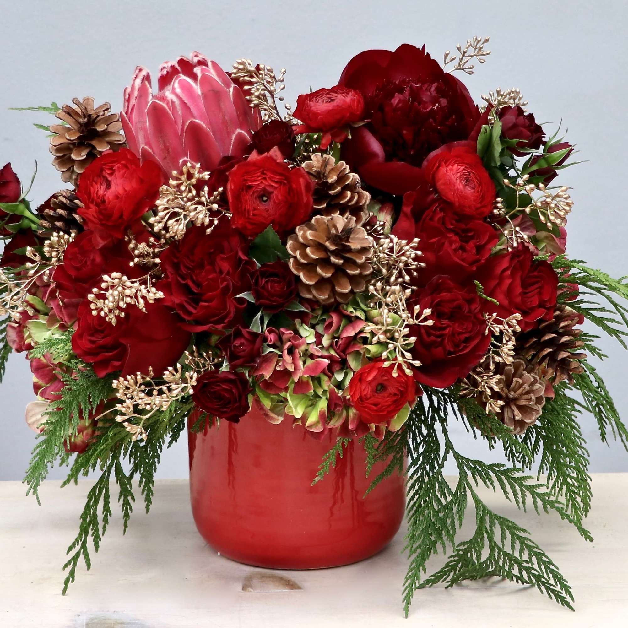 This beautiful arrangement includes a mix of vibrant red roses, hydrangeas, and