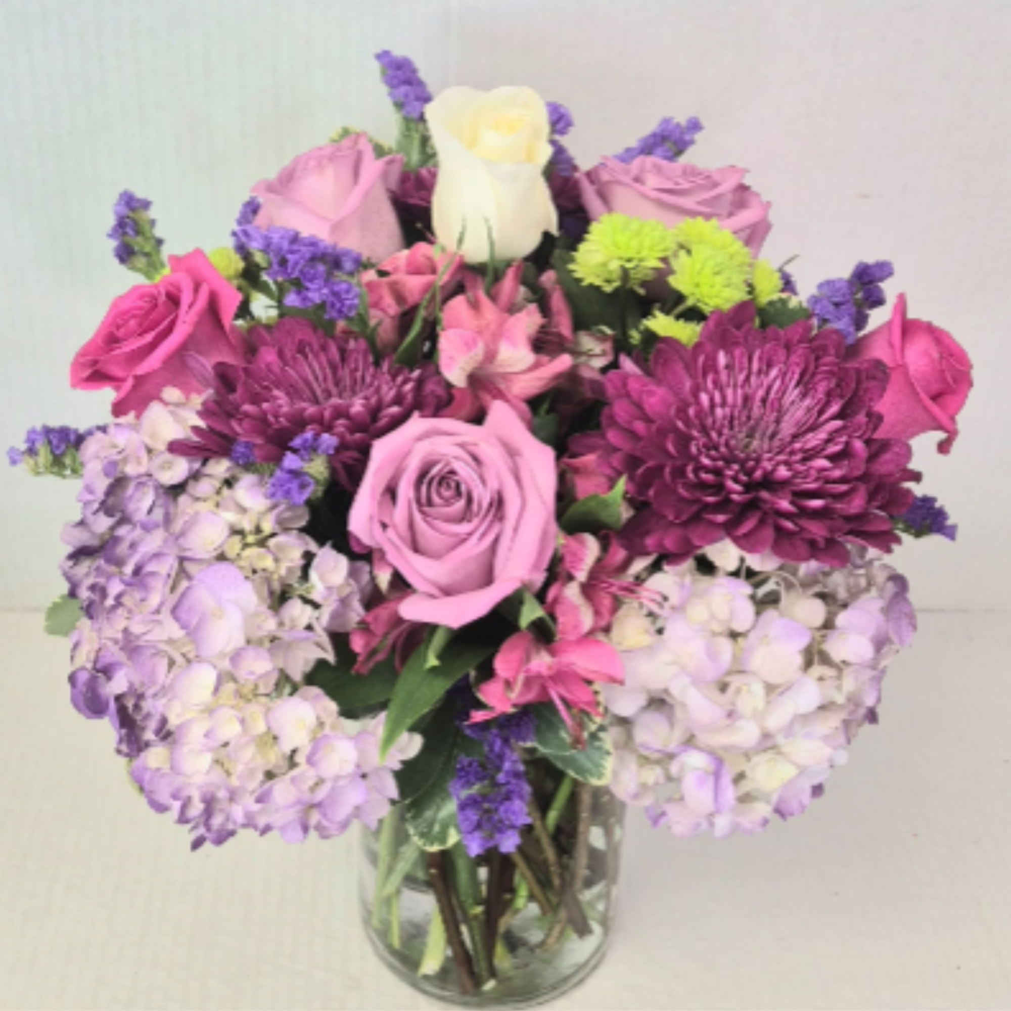A vibrant and lush gift of assorted flowers and roses surrounded by