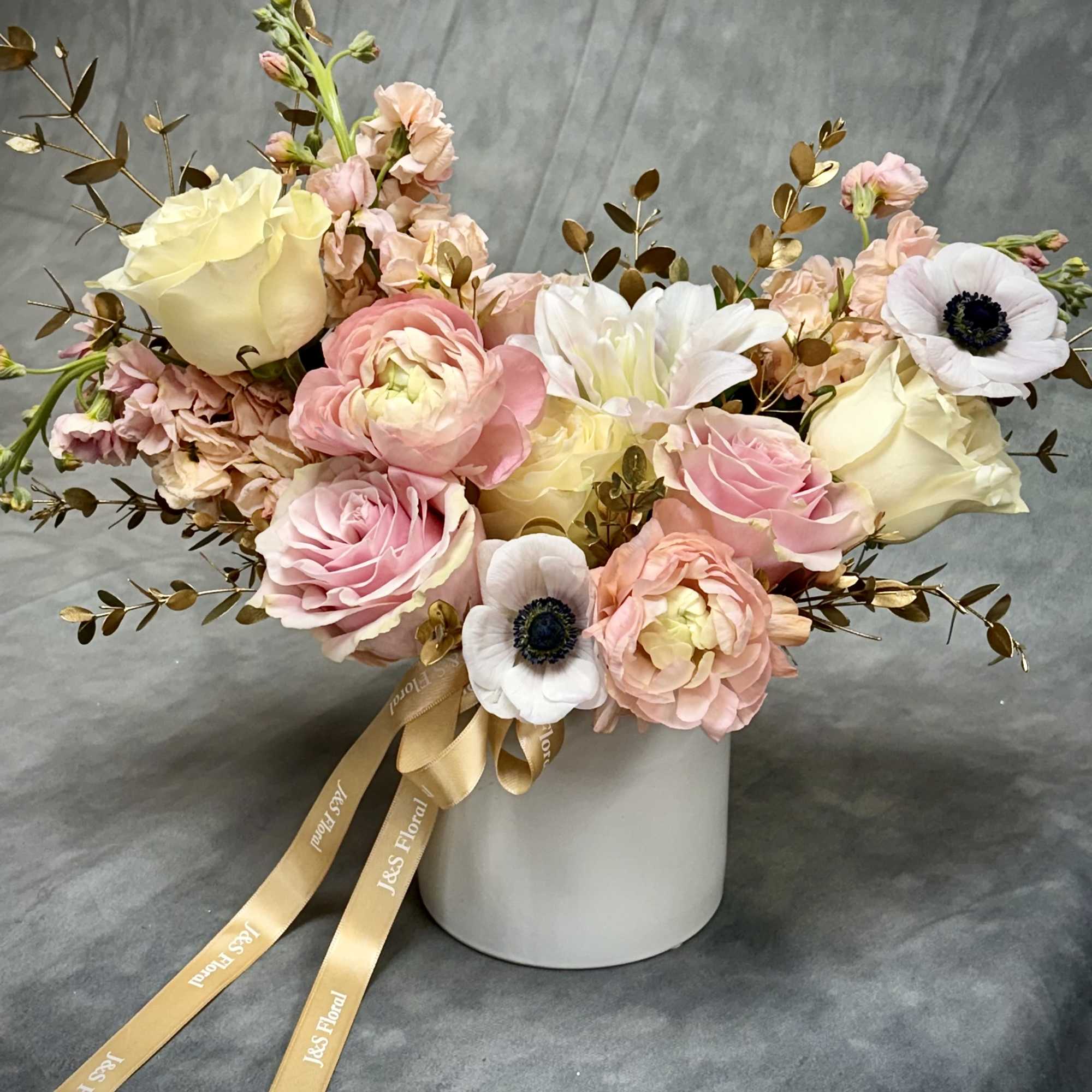 Golden Grace
Soft blush, ivory, and peach blooms paired with golden accents create