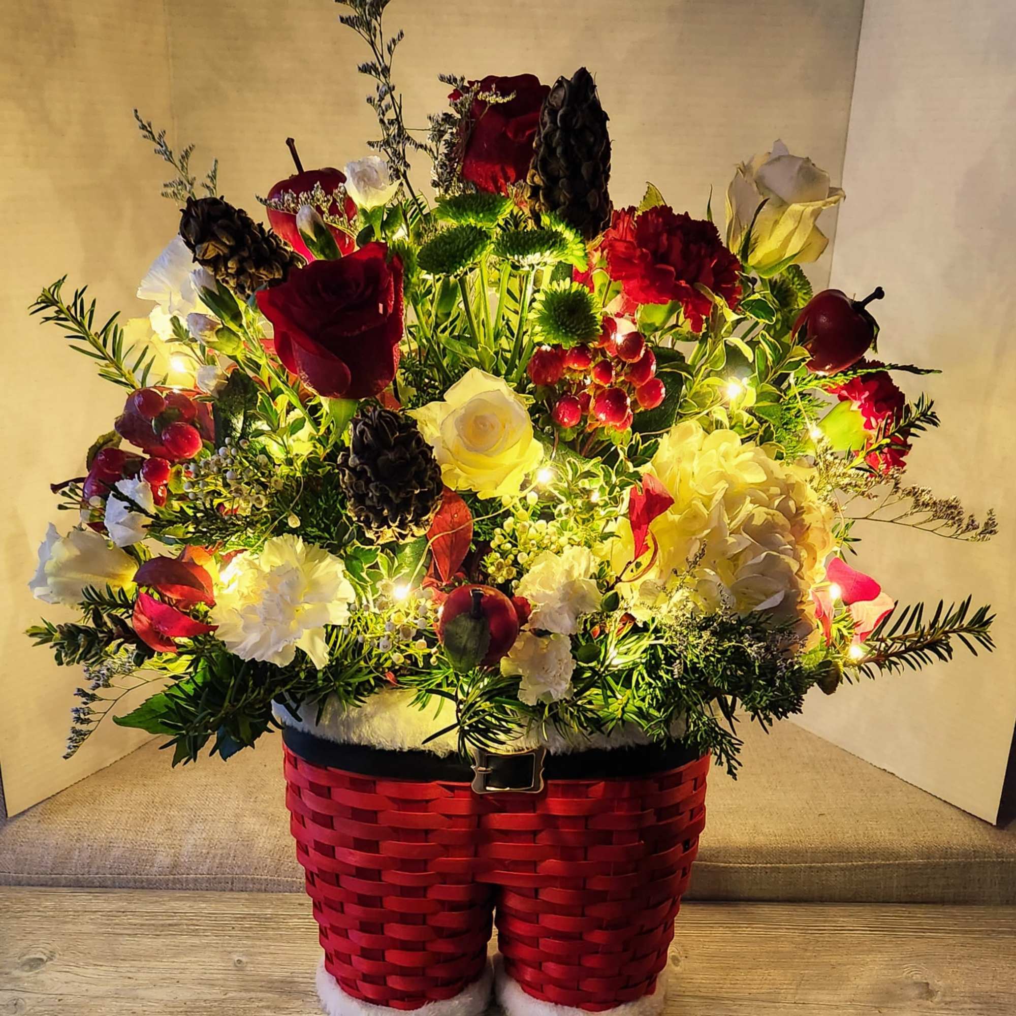 A mixture of seasonal greens and flowers in reds. Whites, and greens