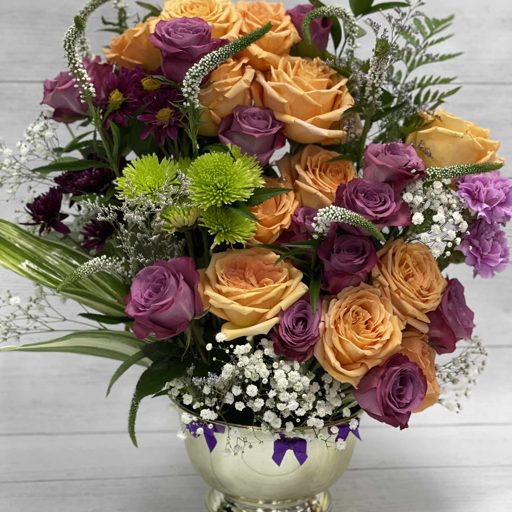 A mix of orange and deep purple roses with a touch of