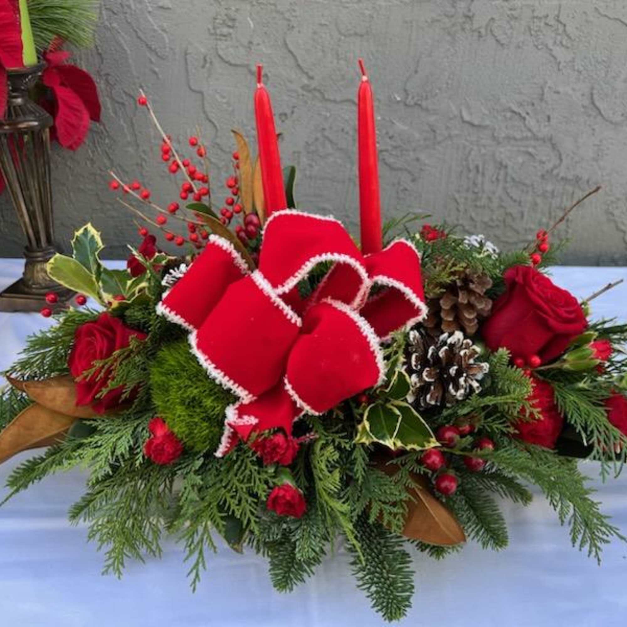 A beautiful centerpiece for Christmas, with a red ribbon and two red