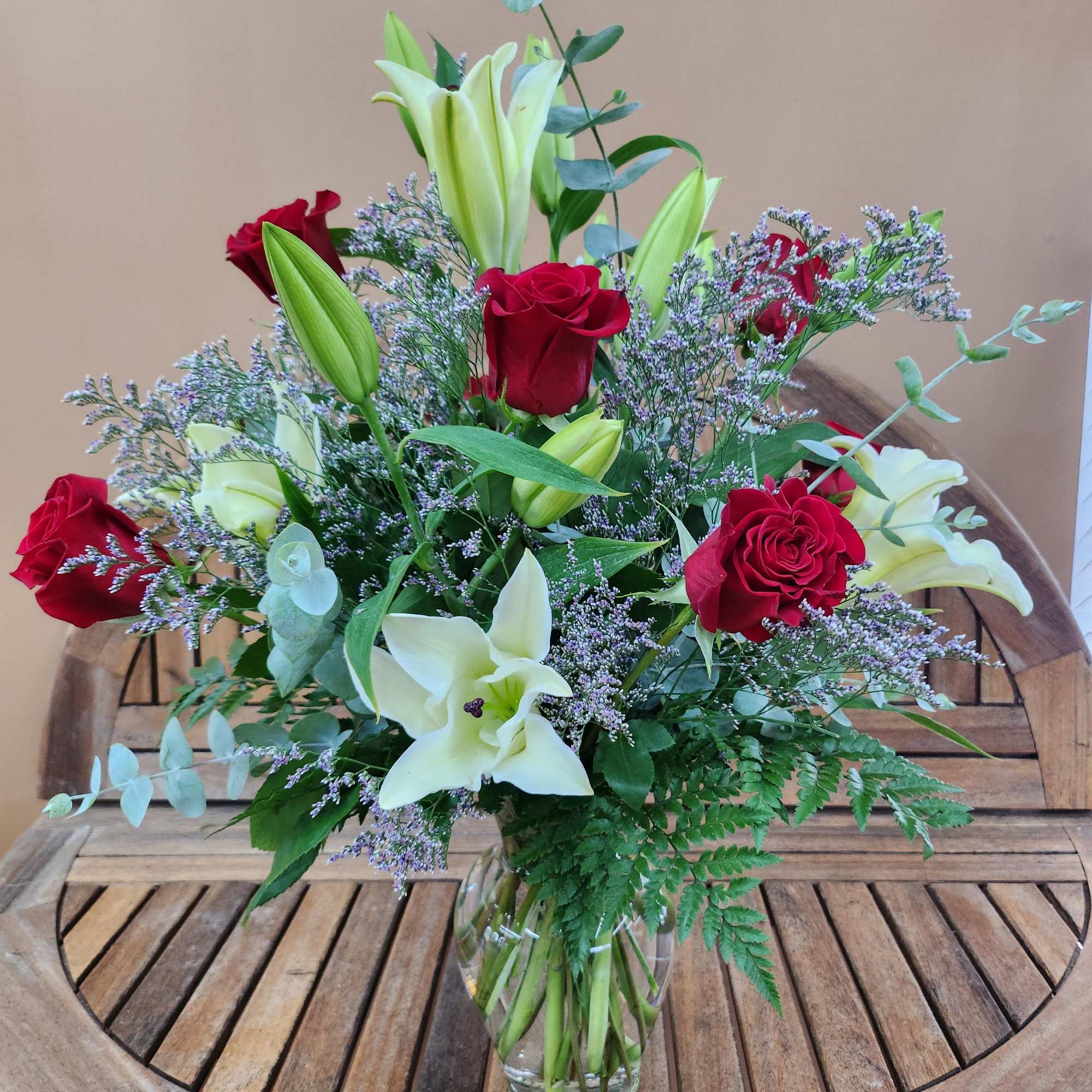 A mixture of red roses and white lilies with fifiller and greens