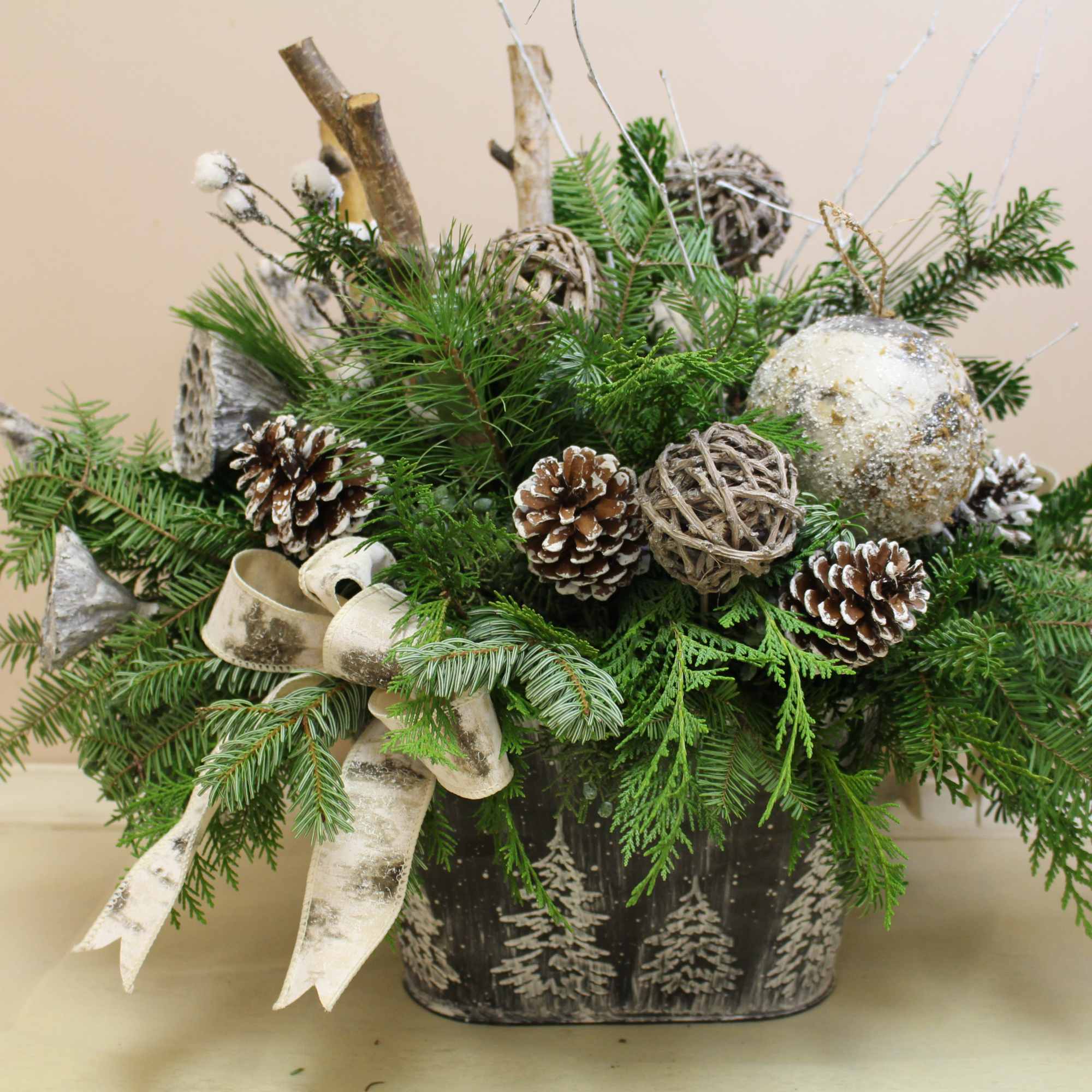 A galvanized container with edged trees is filled with balsam, pine, cedar