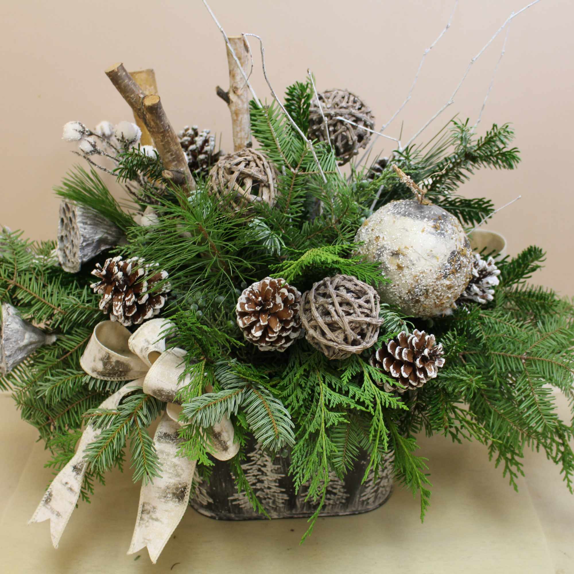 A galvanized container with edged trees is filled with balsam, pine, cedar