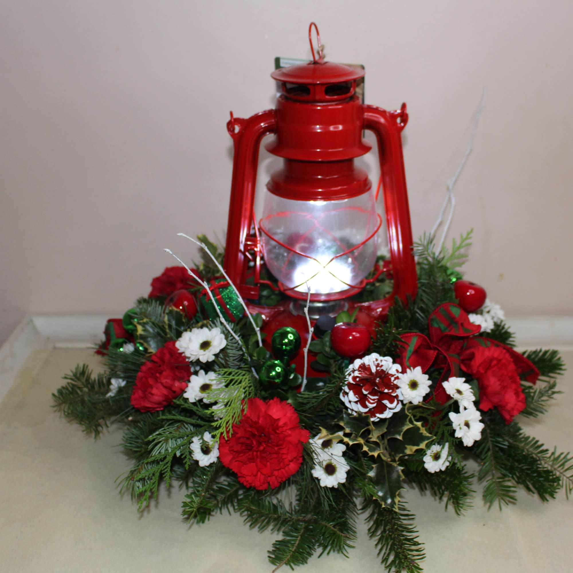 Unique old fashion lantern surrounded by a lovely Christmas arrangement.  