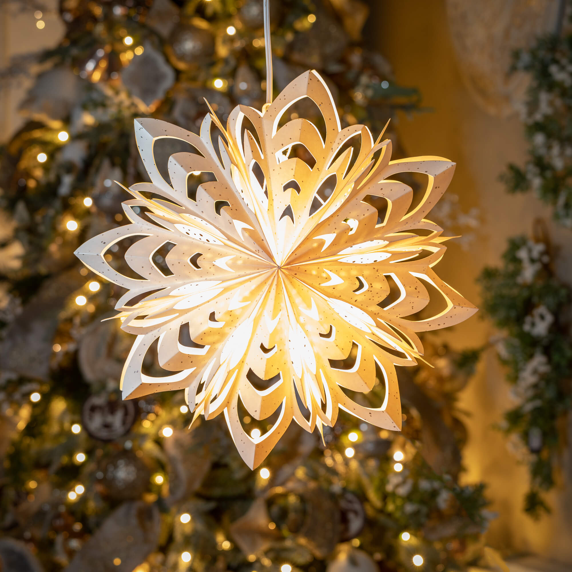 Reminiscent of a homemade snowflake, this large intricate paper star adds vintage