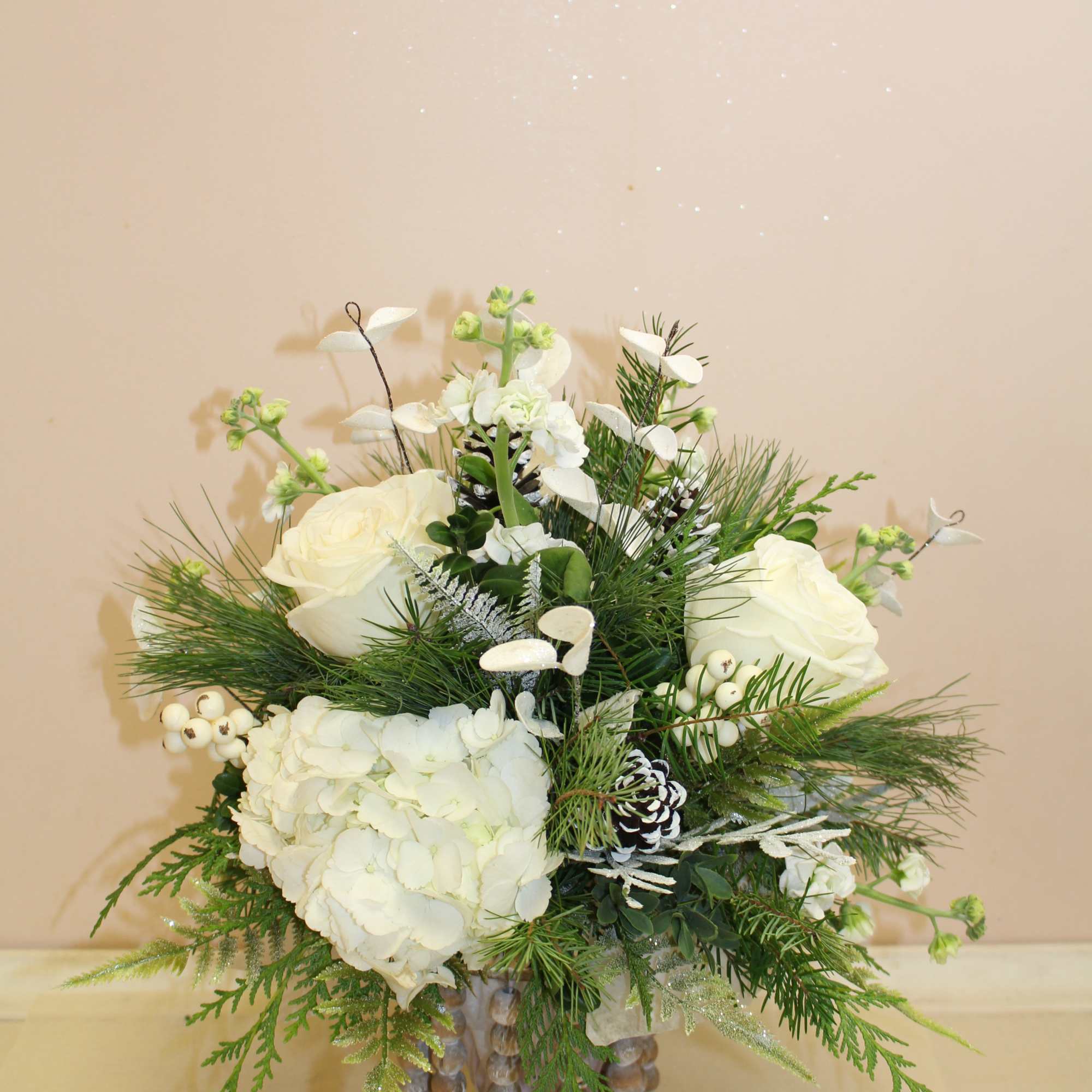 A natural wood farmhouse container filled with evergreens and white hydrangea and