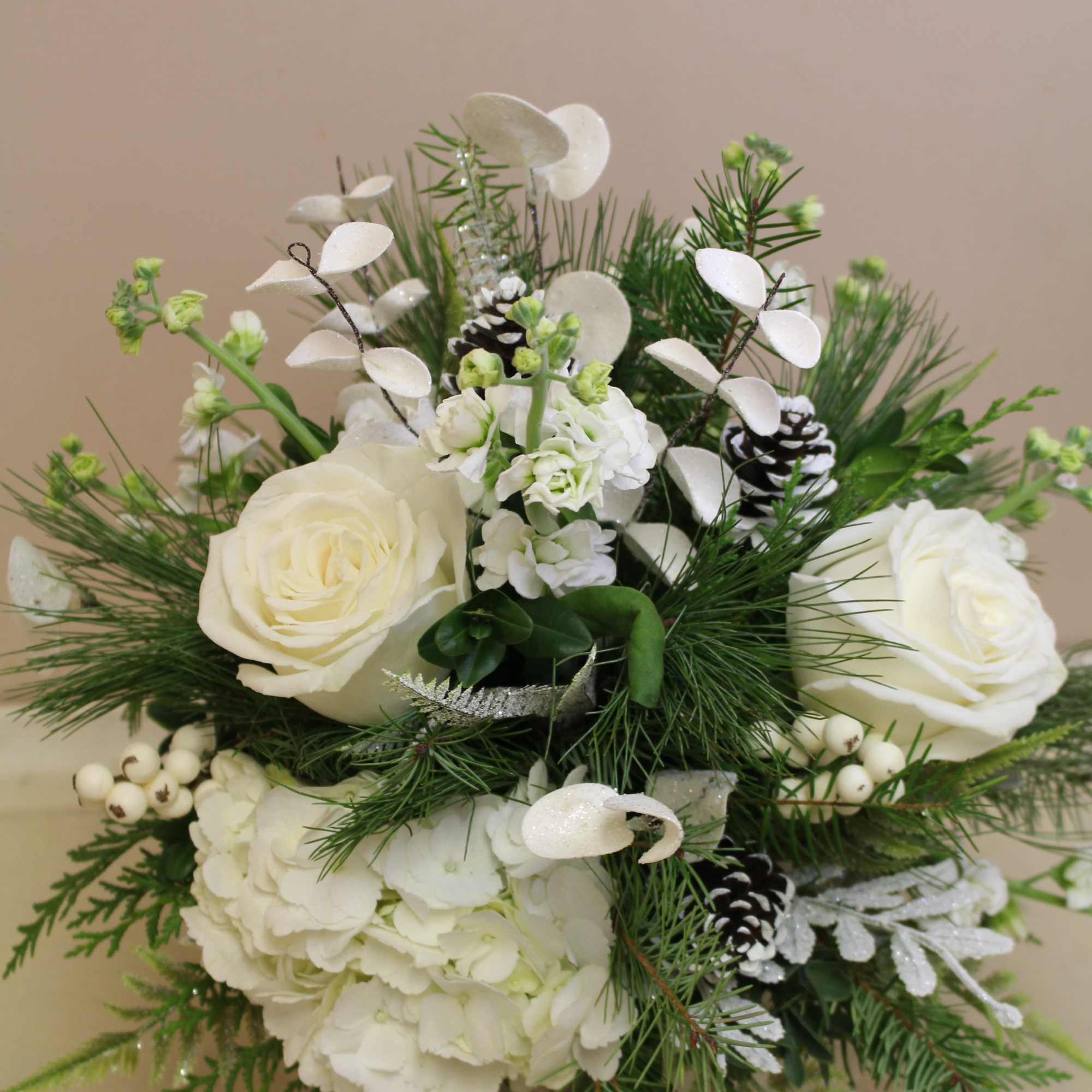 A natural wood farmhouse container filled with evergreens and white hydrangea and