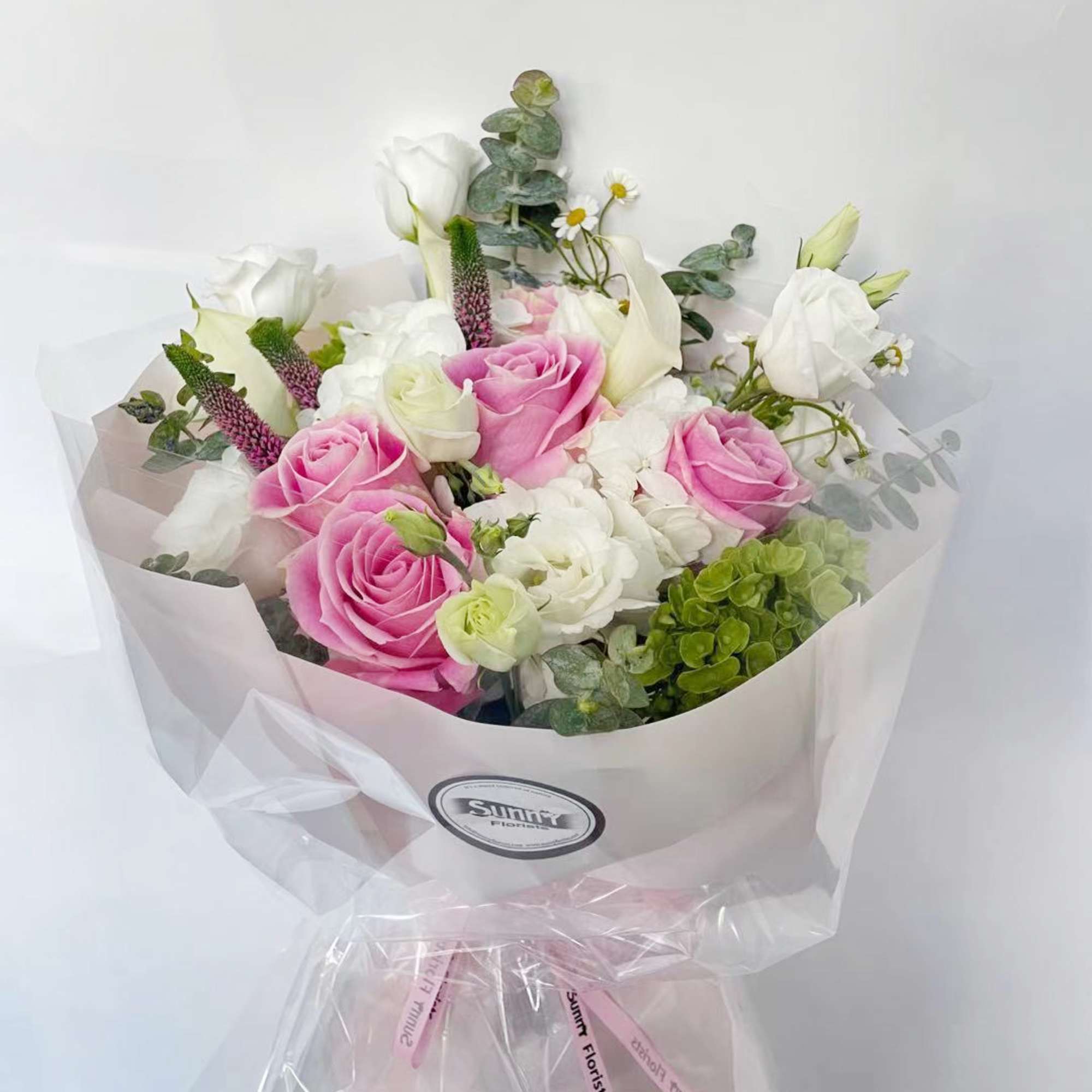 This pastel-colored handtied bouquet includes beautiful pink vandal roses, complemented by white
