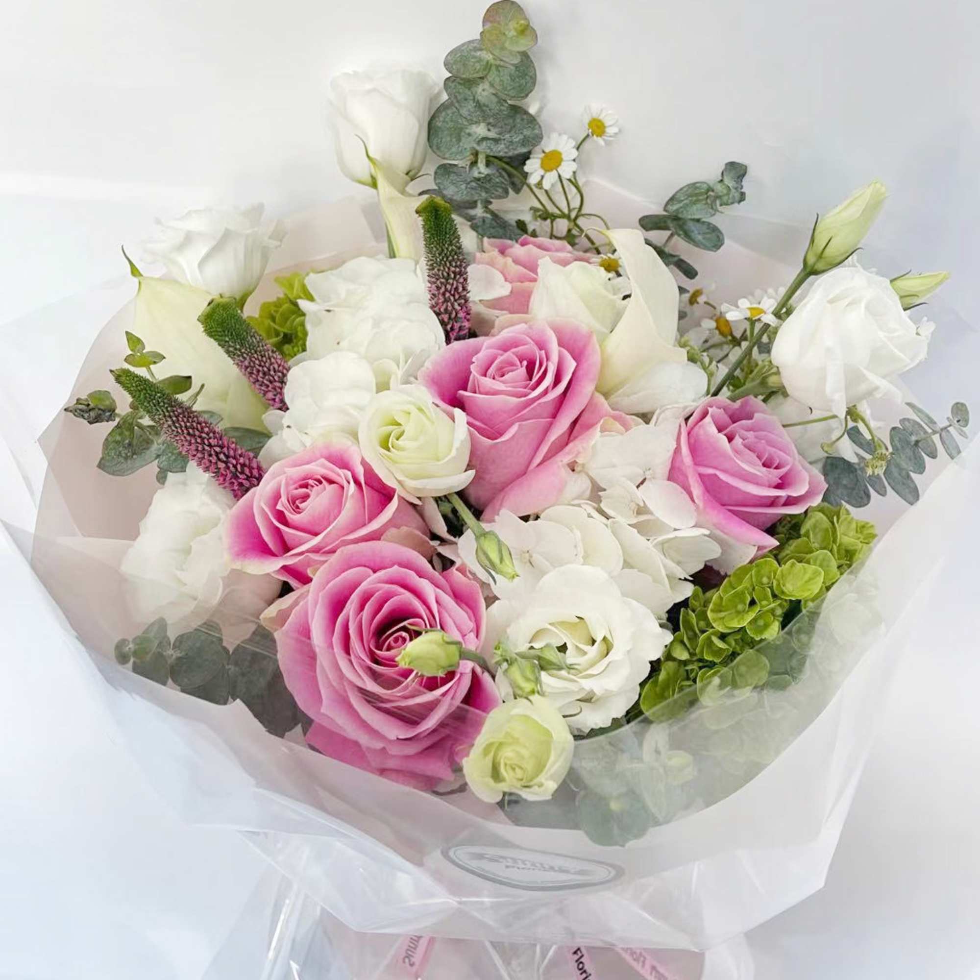 This pastel-colored handtied bouquet includes beautiful pink vandal roses, complemented by white